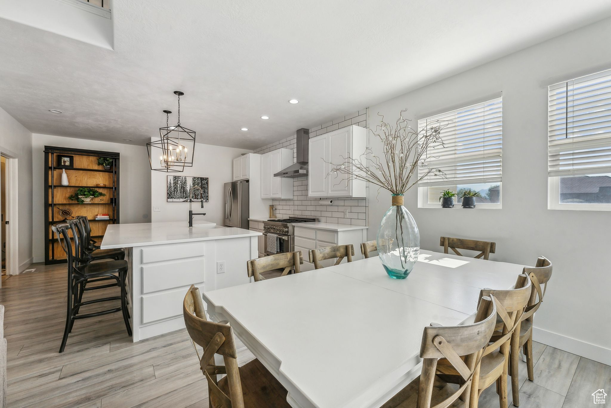 Dining space featuring sink, a wealth of natural light, light wood-type flooring, and a chandelier