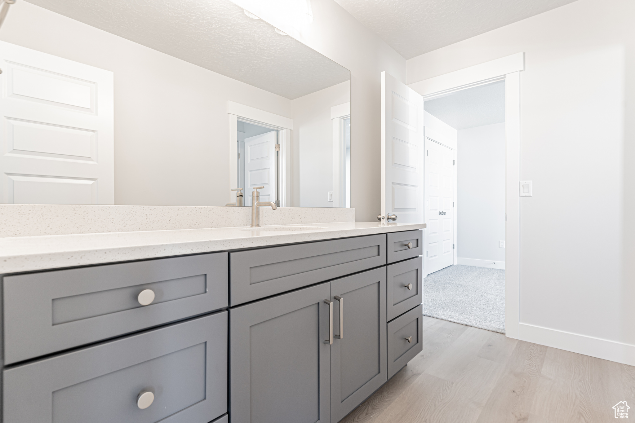 Bathroom with vanity, wood-type flooring, and a textured ceiling