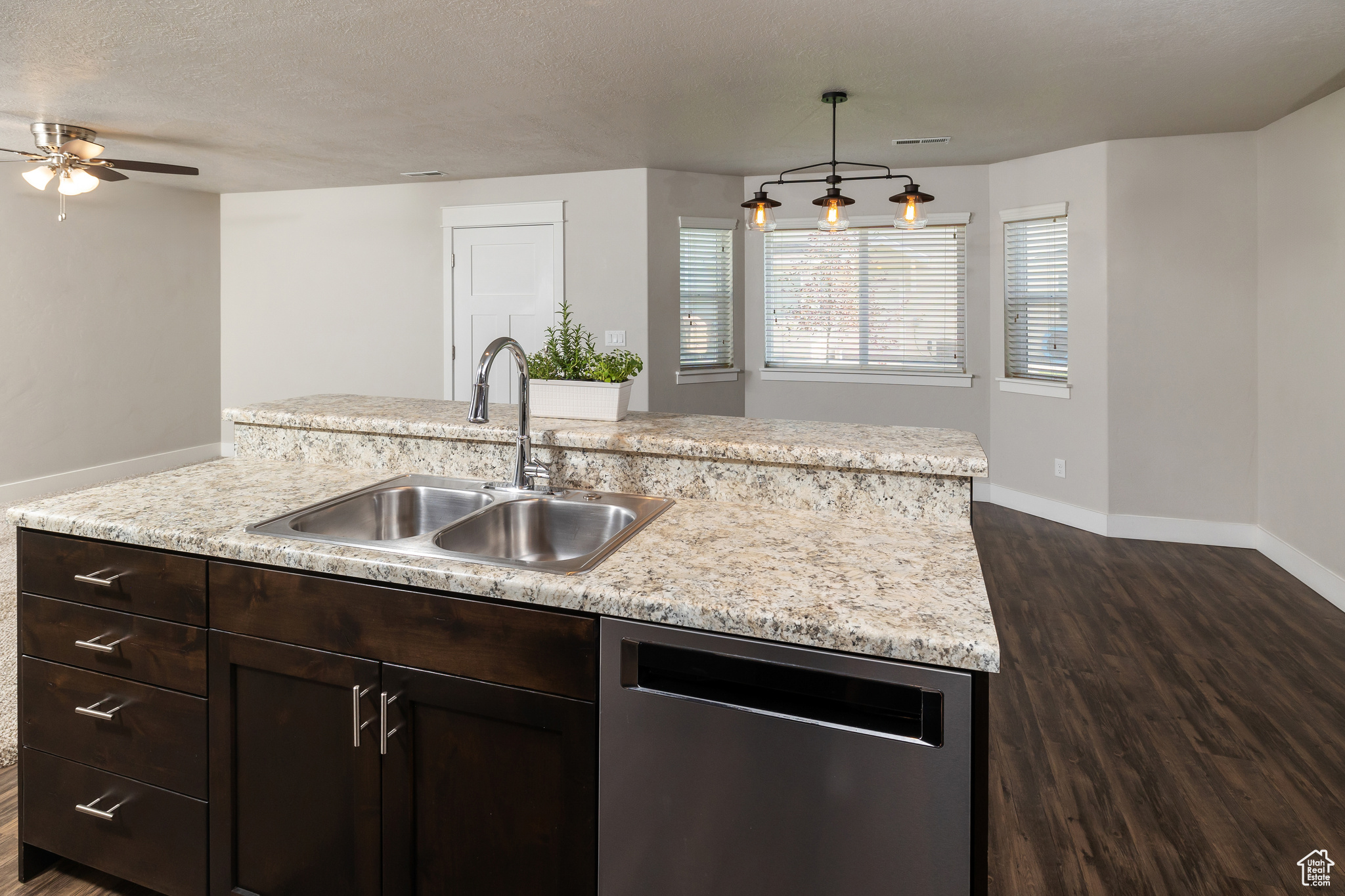 Kitchen with sink, dark hardwood / wood-style flooring, a kitchen island with sink, dishwasher, and ceiling fan