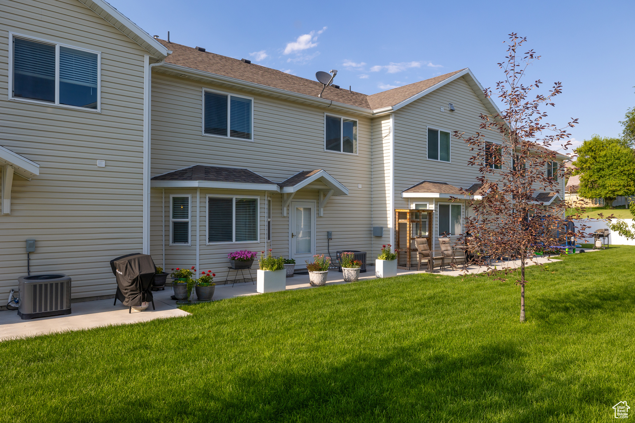 Rear view of house featuring cooling unit, a patio area, and a yard