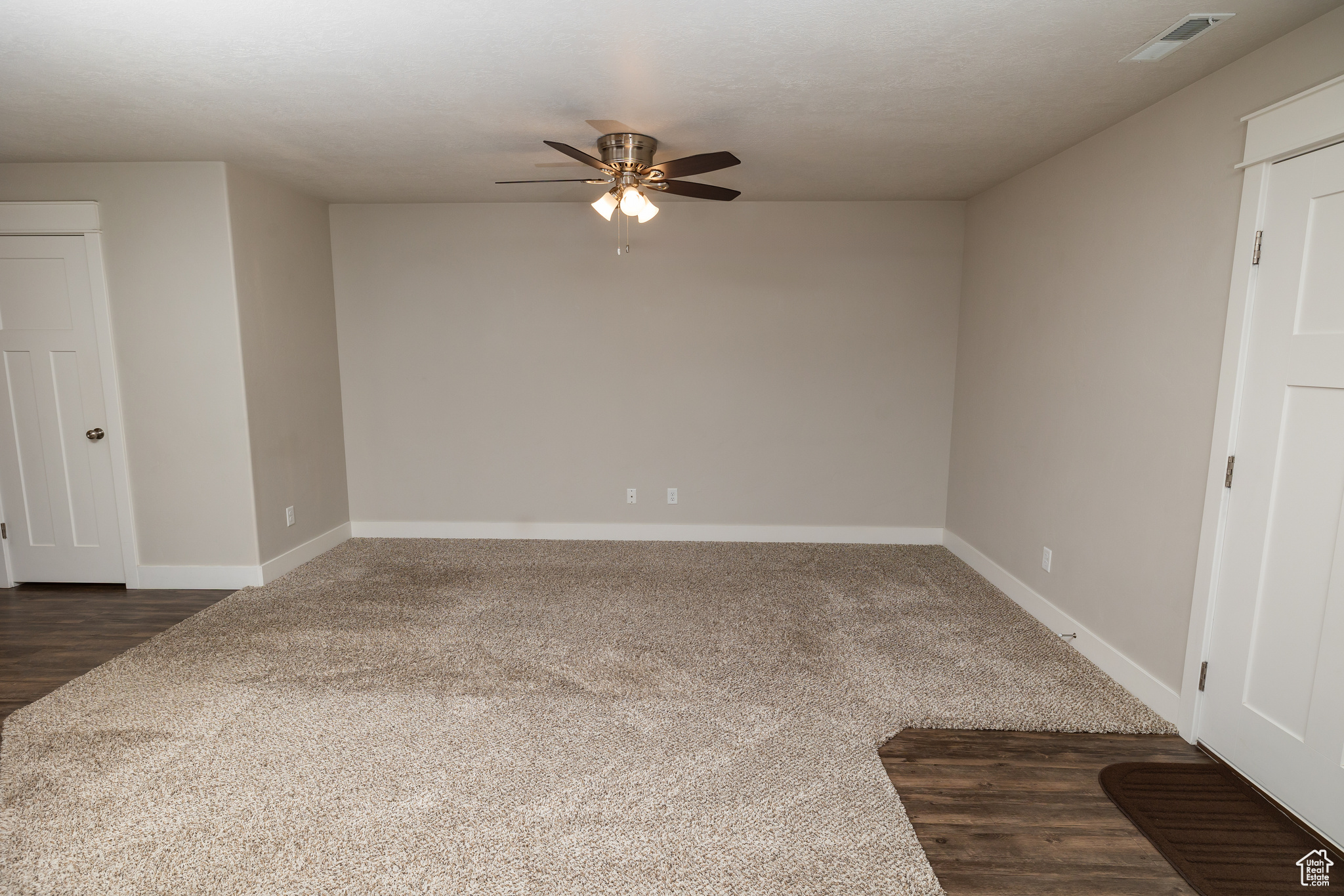 Carpeted spare room featuring ceiling fan