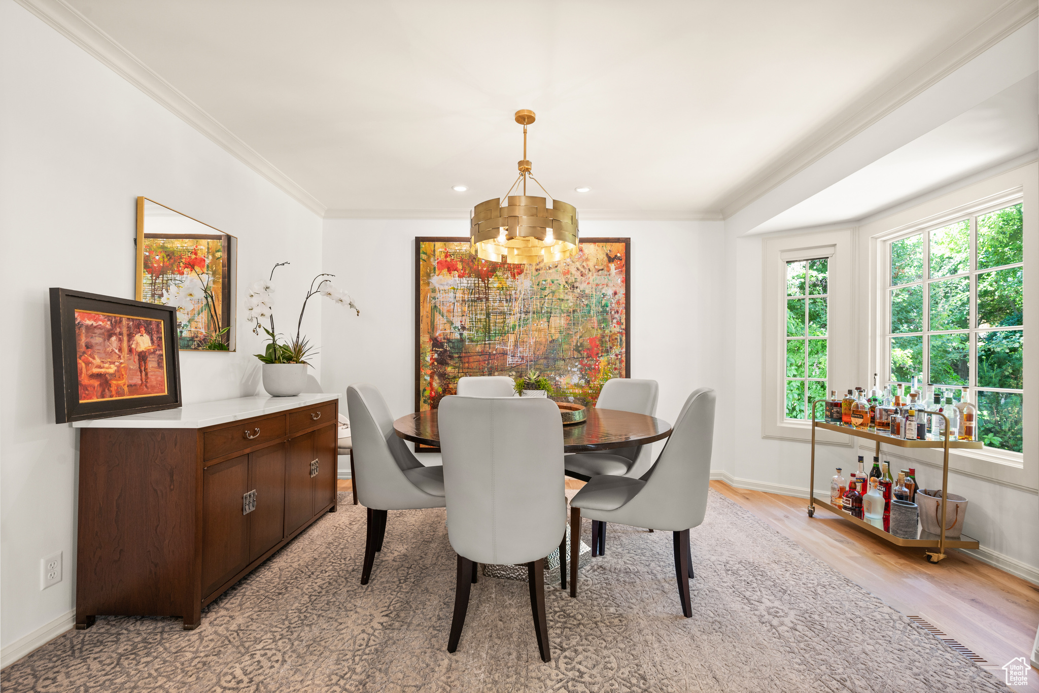 Dining area featuring a chandelier, light wood flooring, and ornamental molding