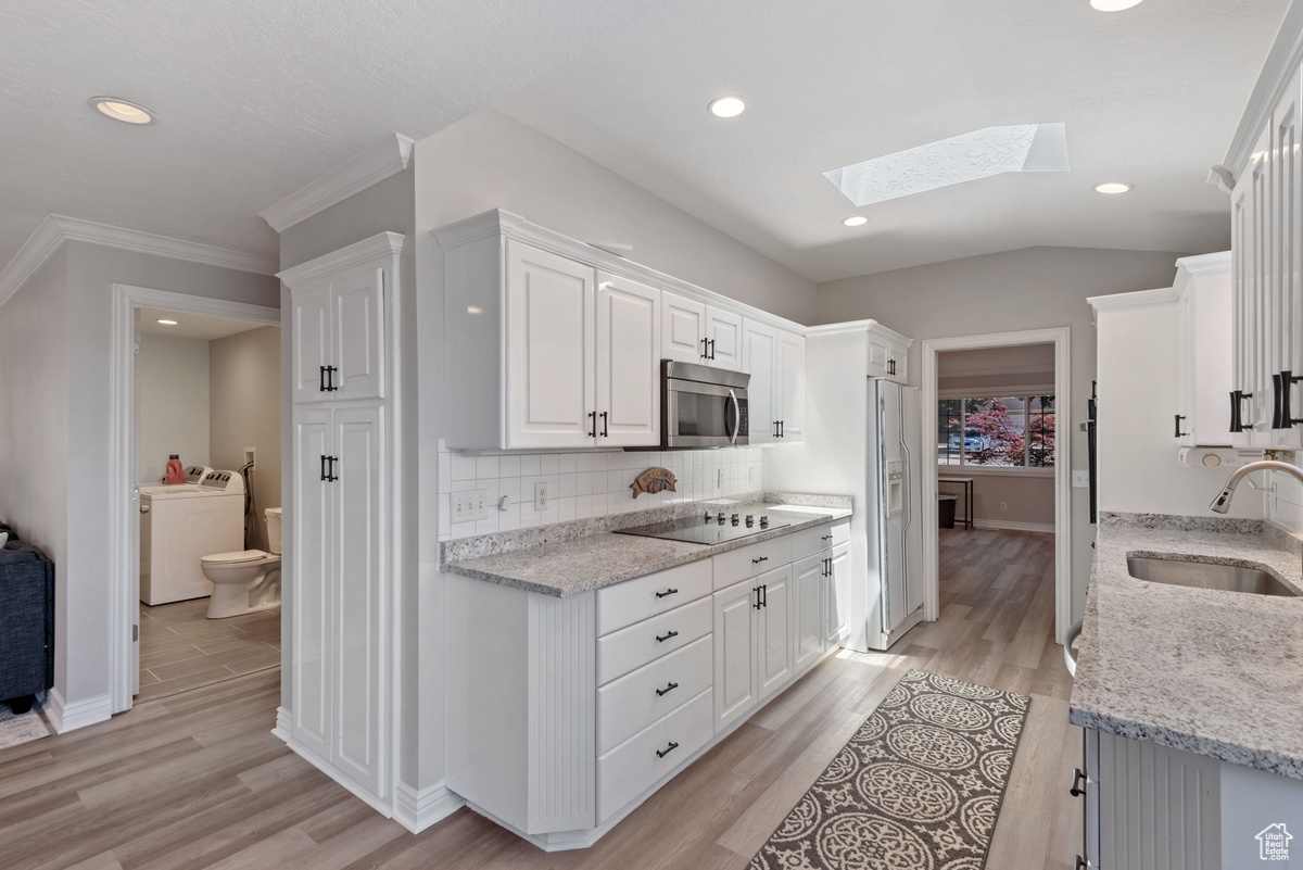 Kitchen featuring sink, light hardwood / wood-style flooring, and washer / dryer