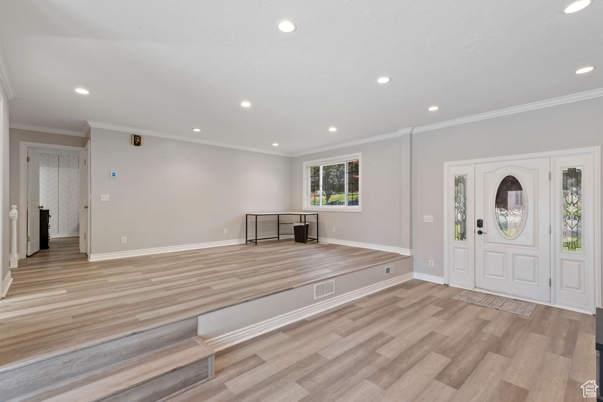 Foyer featuring ornamental molding and light hardwood / wood-style floors