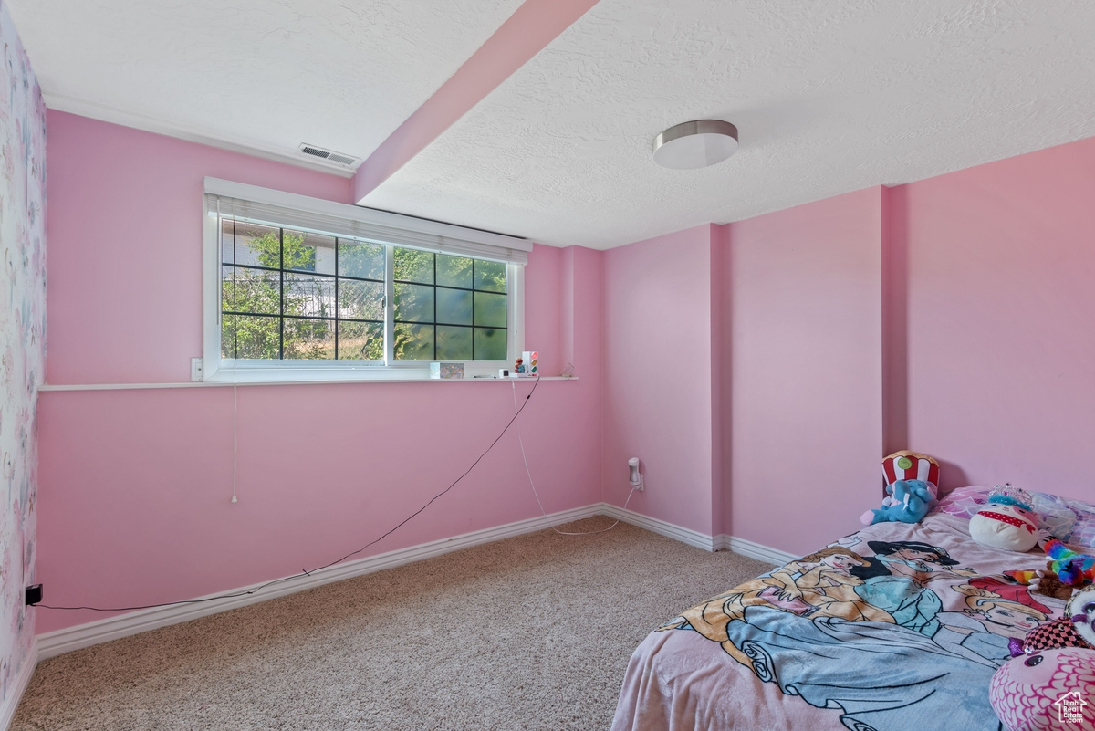 Unfurnished bedroom with carpet and a textured ceiling