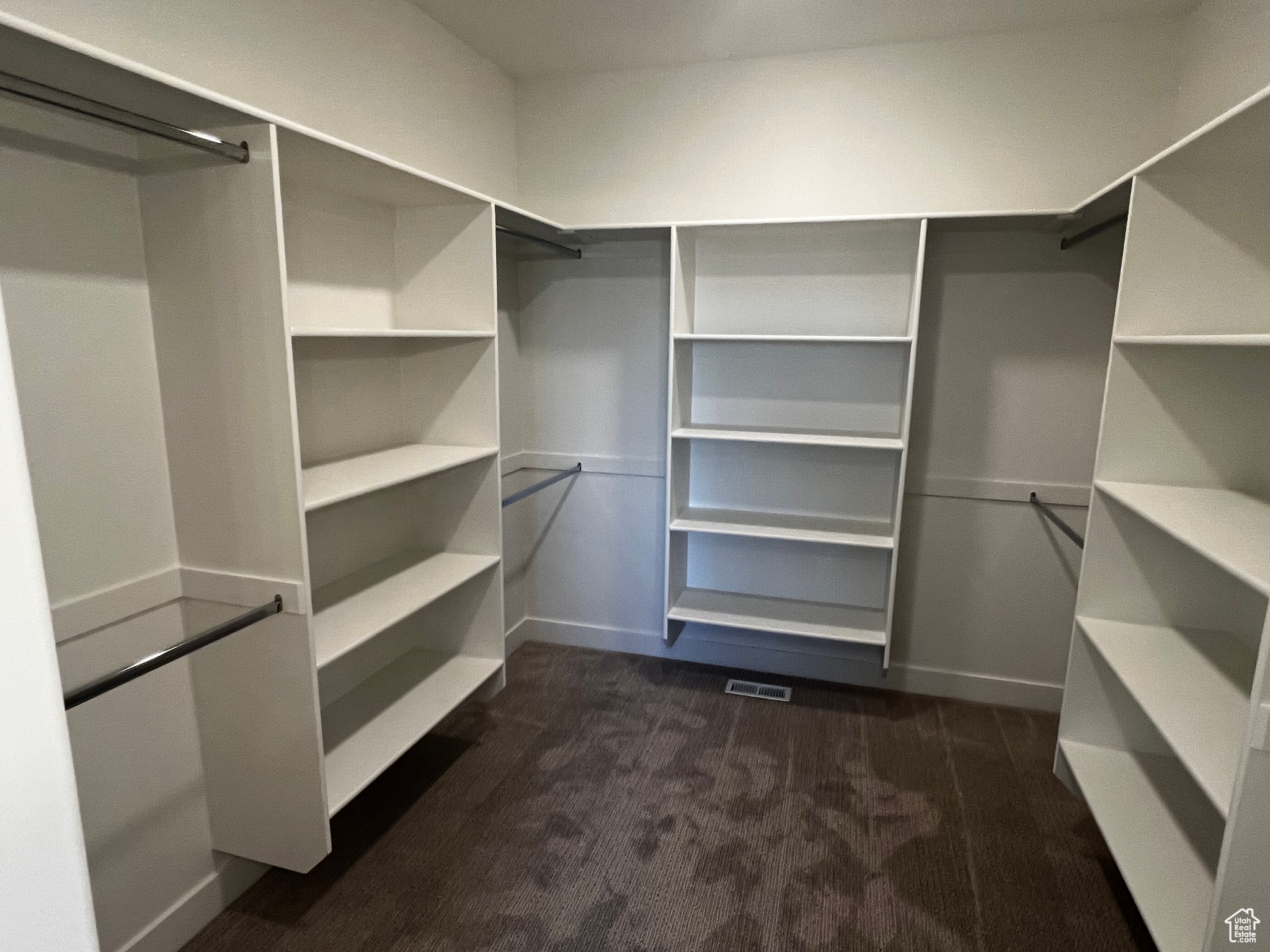 Walk in closet featuring dark colored carpet