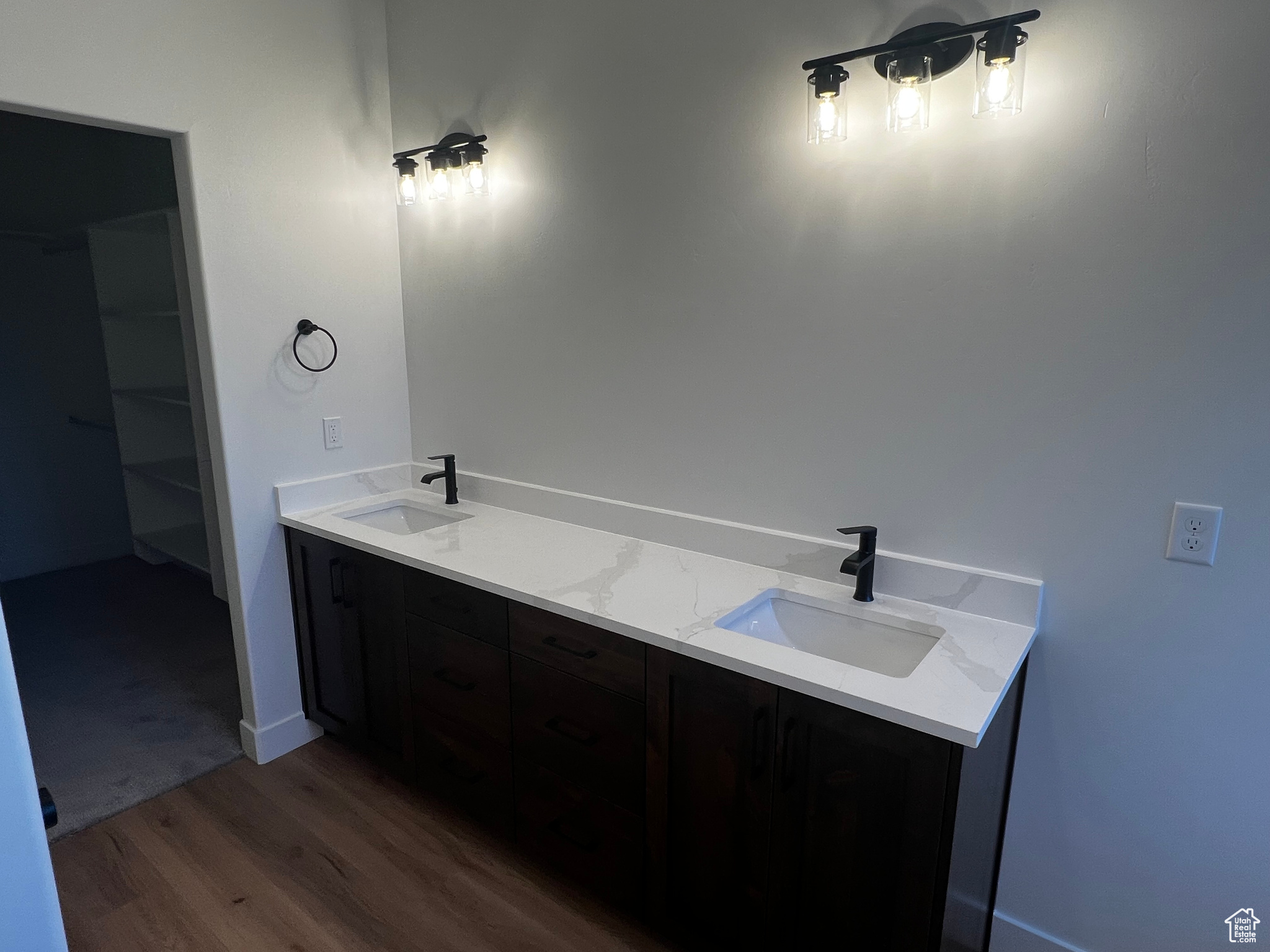 Bathroom featuring dual vanity and wood-type flooring