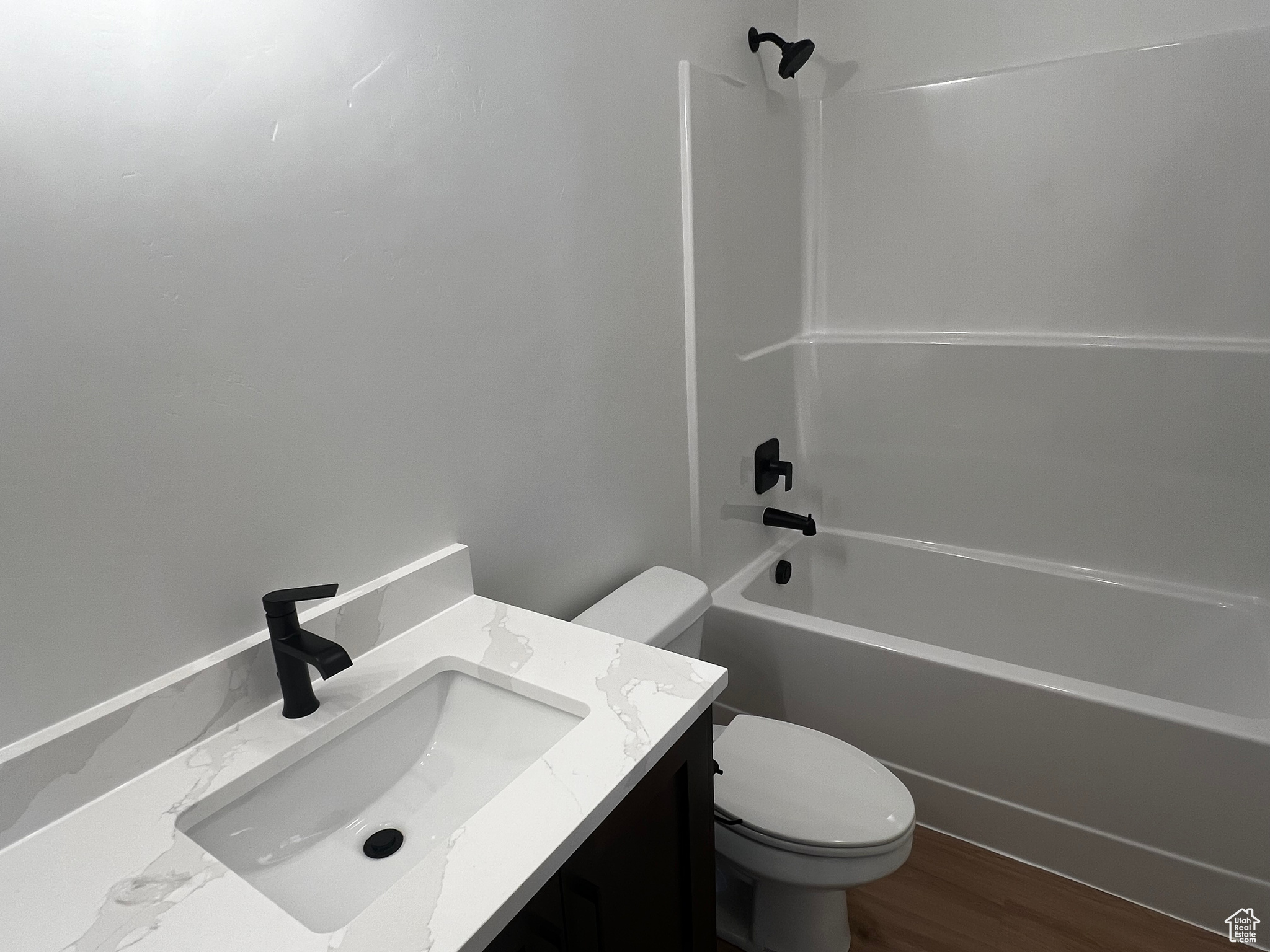 Full bathroom with toilet, hardwood / wood-style flooring, bathtub / shower combination, and vanity