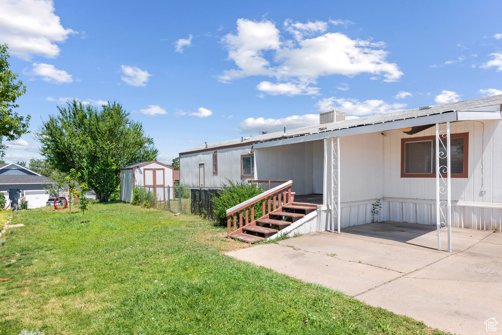 Exterior space featuring a shed, a patio area, and a front yard