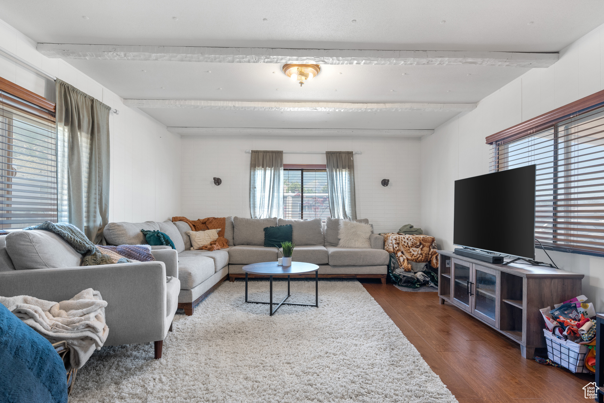 Living room with beamed ceiling and hardwood / wood-style flooring