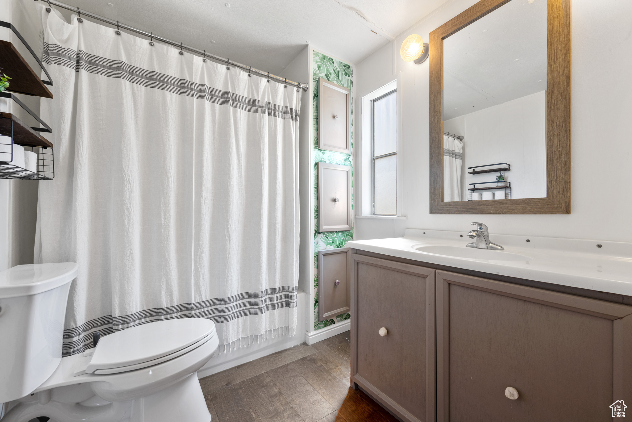 Bathroom featuring hardwood / wood-style flooring, toilet, and vanity