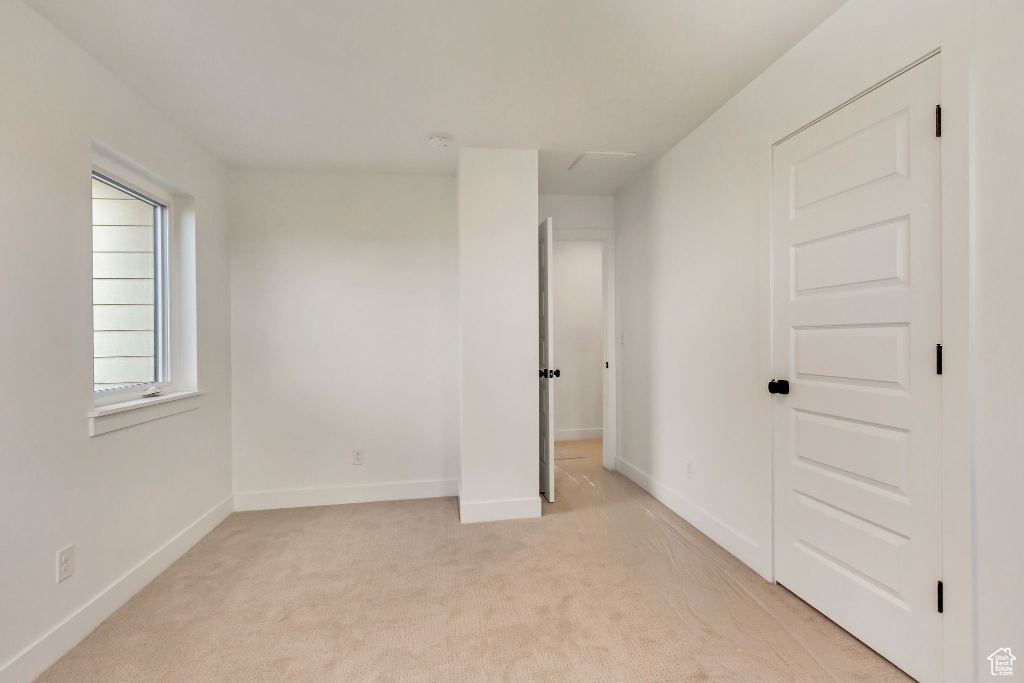 Unfurnished room featuring light carpet