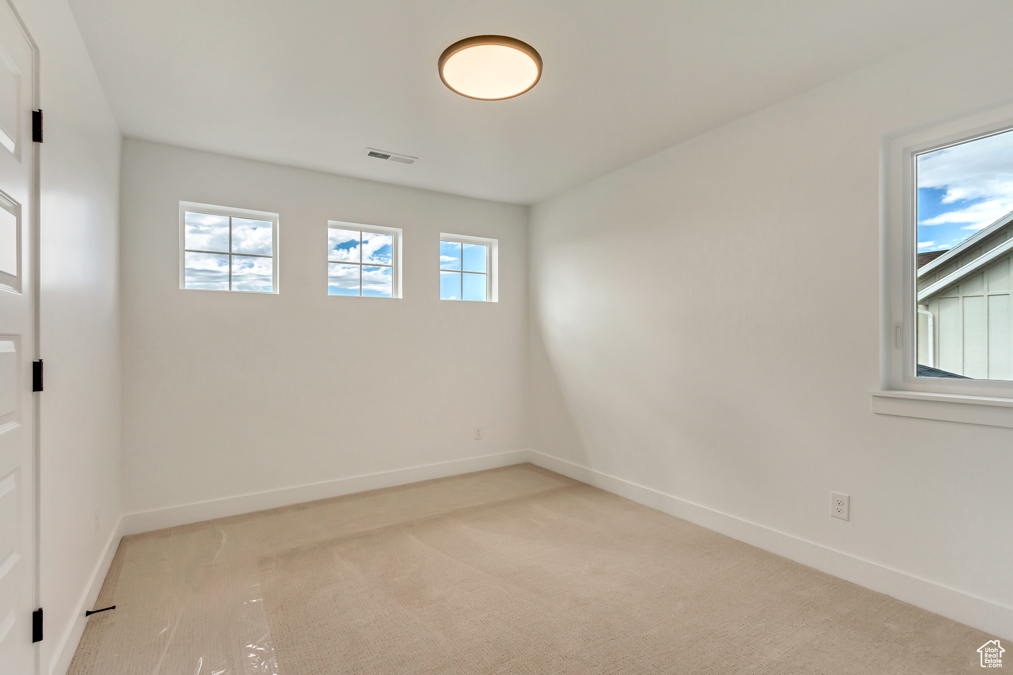 Carpeted empty room featuring a wealth of natural light