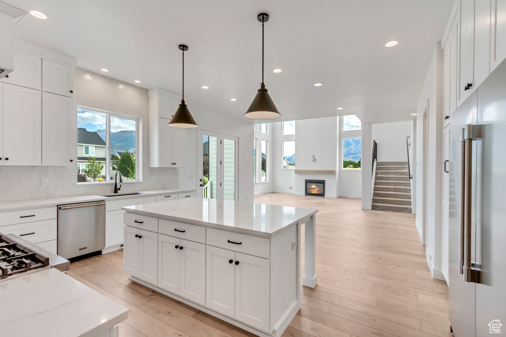 Kitchen with backsplash, stainless steel appliances, plenty of natural light, and light wood-type flooring