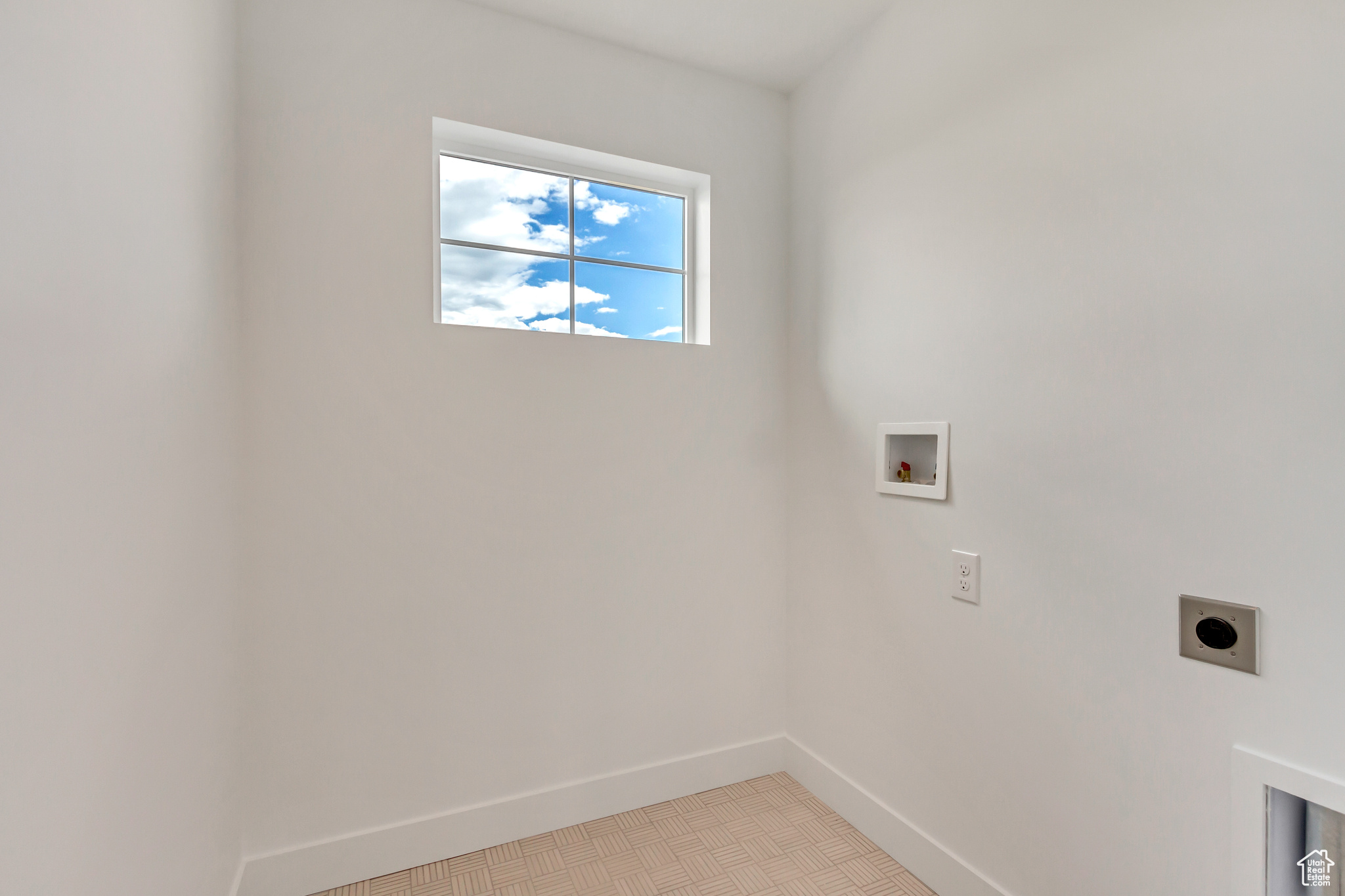 Washroom with light tile patterned floors, hookup for a washing machine, and electric dryer hookup