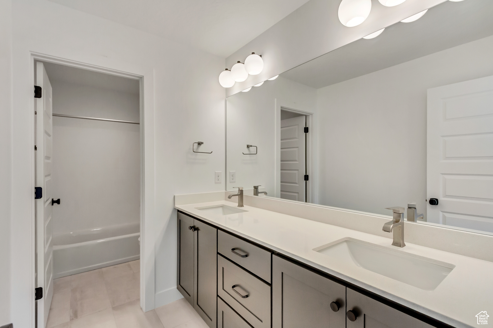 Bathroom with bathing tub / shower combination, tile patterned flooring, and vanity