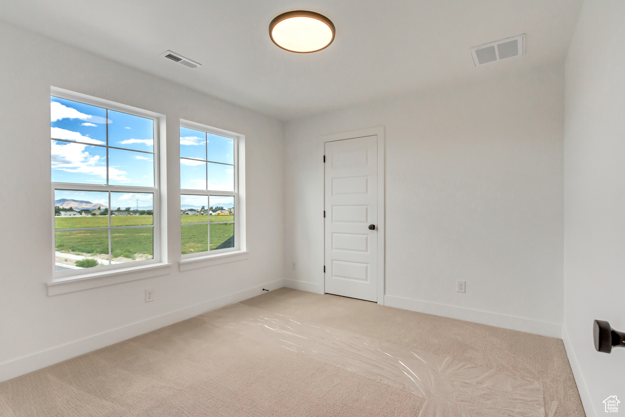 Empty room featuring light colored carpet