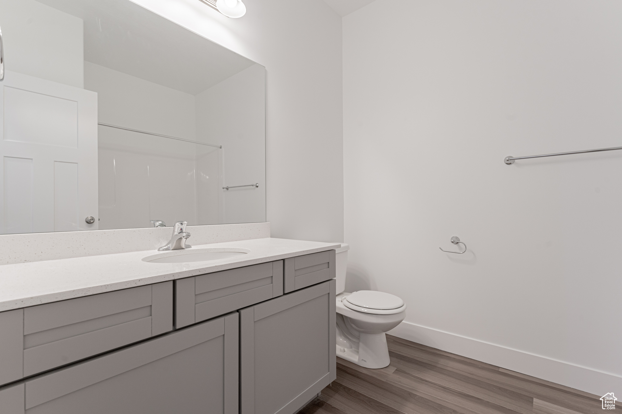 Bathroom featuring hardwood / wood-style flooring, toilet, and vanity