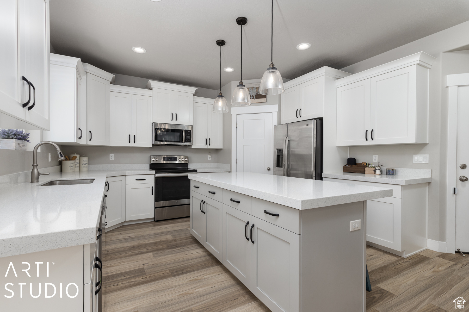 Kitchen featuring light hardwood / wood-style floors, white cabinetry, a center island, and stainless steel appliances