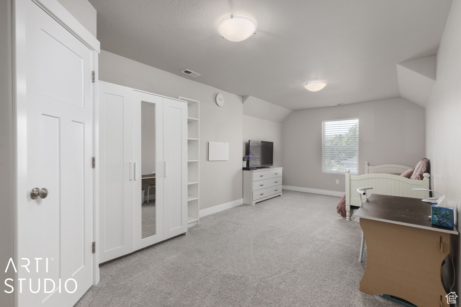 Carpeted bedroom featuring lofted ceiling