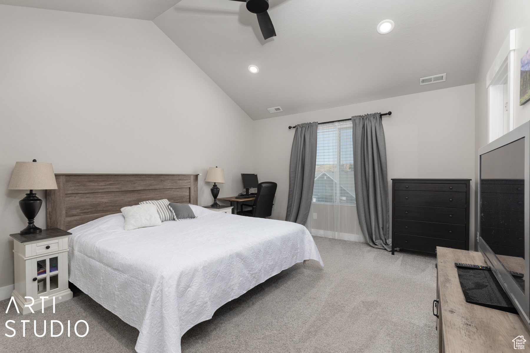 Carpeted bedroom featuring ceiling fan and lofted ceiling