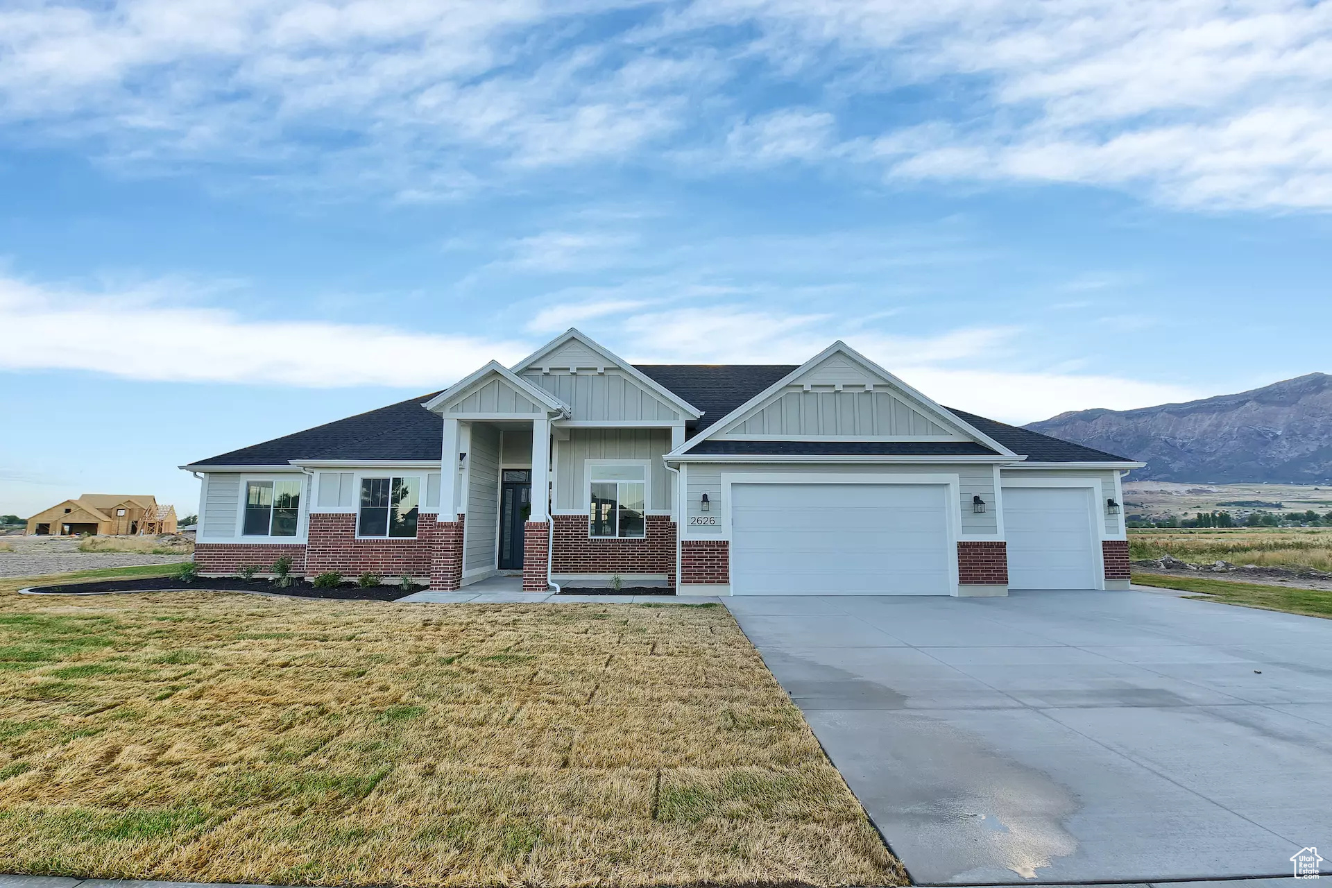 Craftsman inspired home with a garage, a mountain view, and a front yard