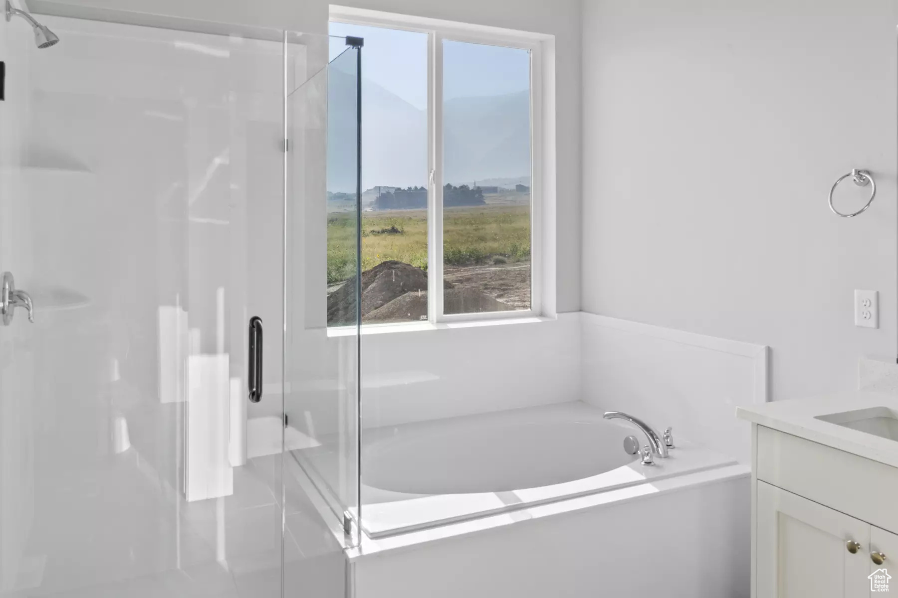 Bathroom with vanity, independent shower and bath, and a wealth of natural light