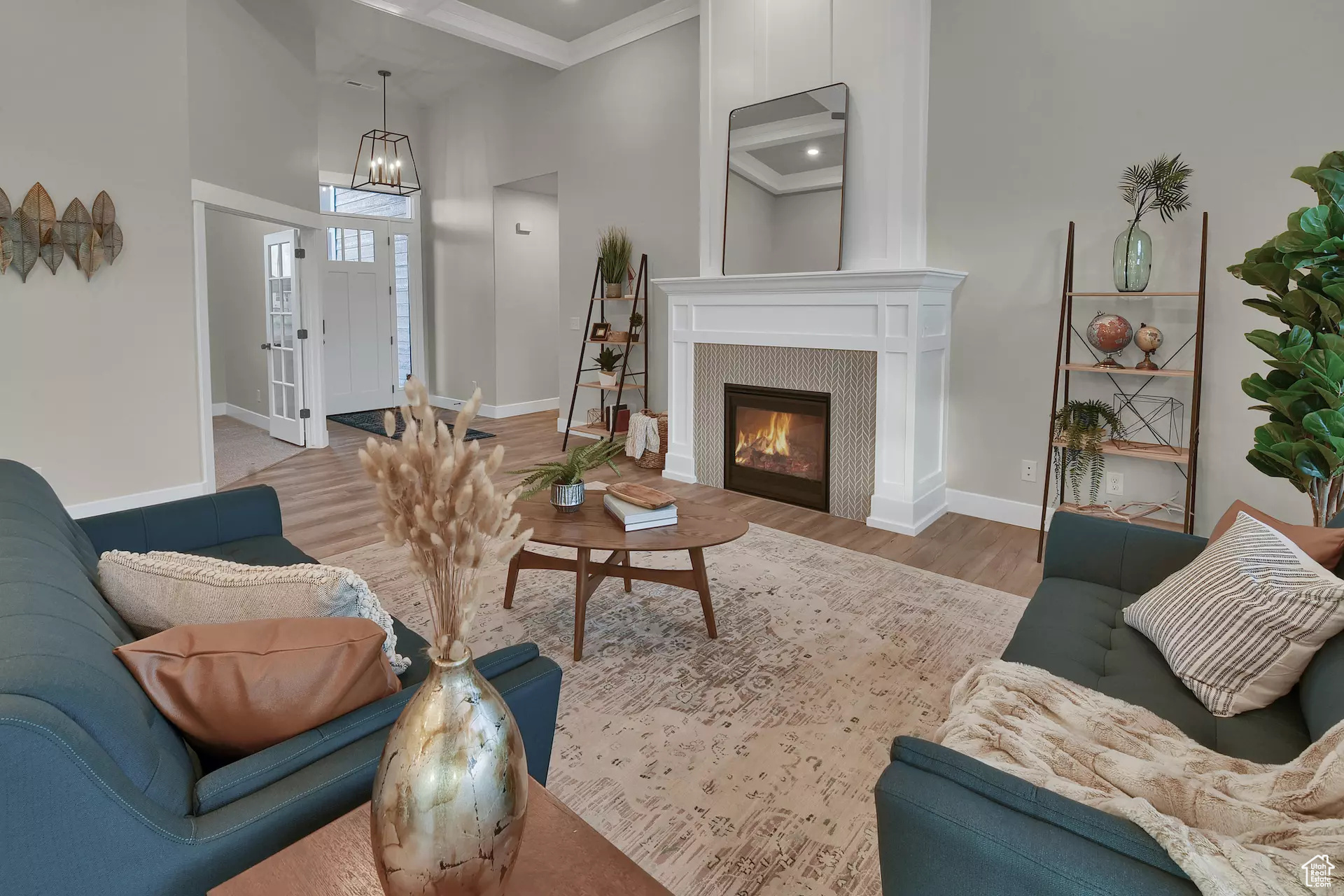 Living room featuring hardwood / wood-style floors, a tiled fireplace, and a towering ceiling