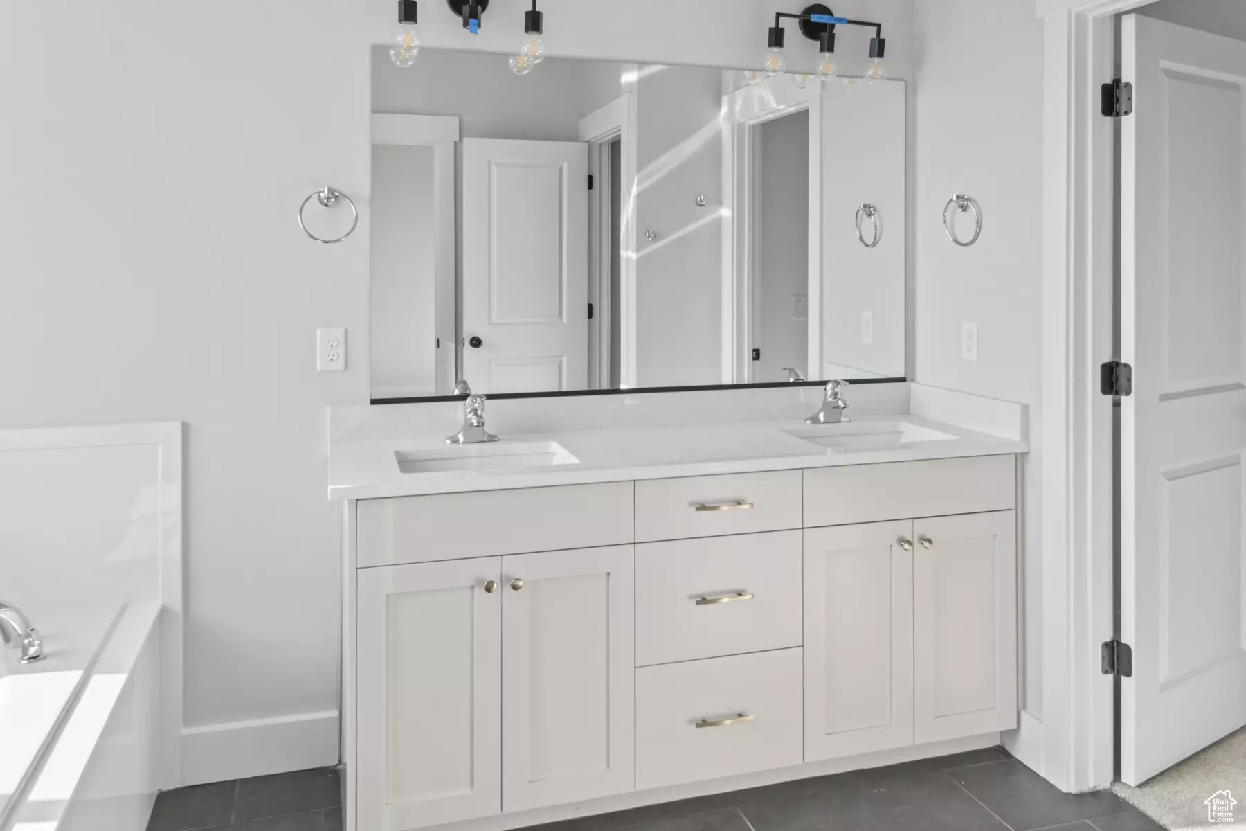 Bathroom featuring double sink vanity, a bathing tub, and tile patterned flooring