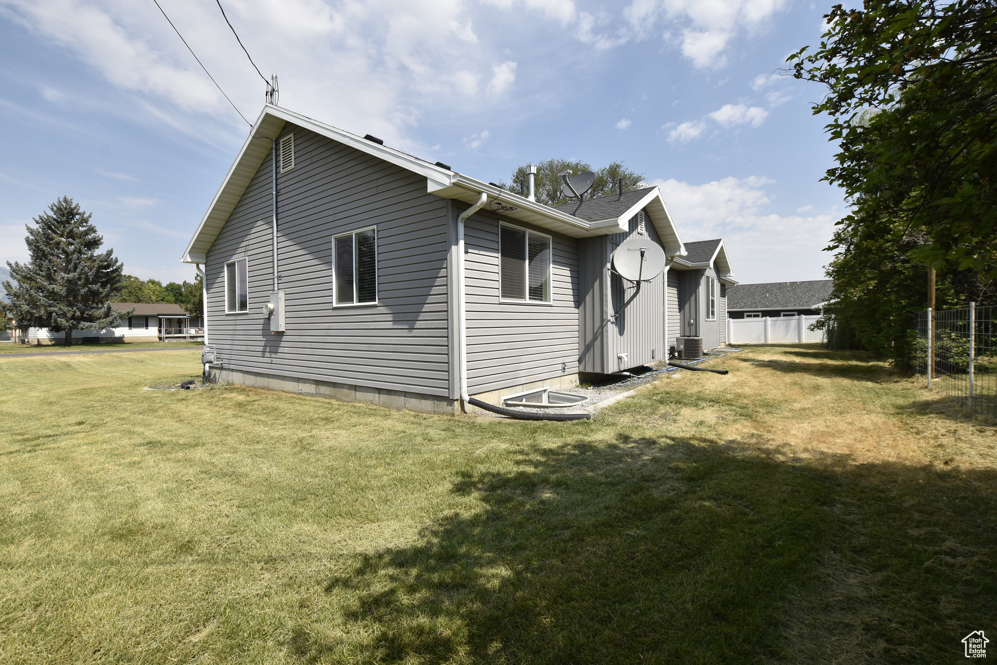 Back of property with central AC and a yard