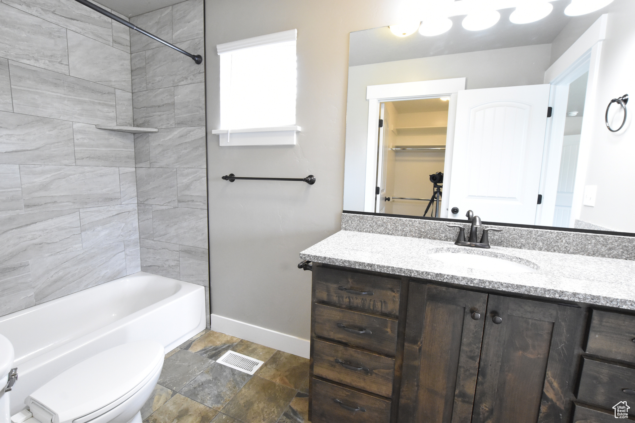 Full bathroom featuring vanity, tiled shower / bath, tile patterned flooring, and toilet