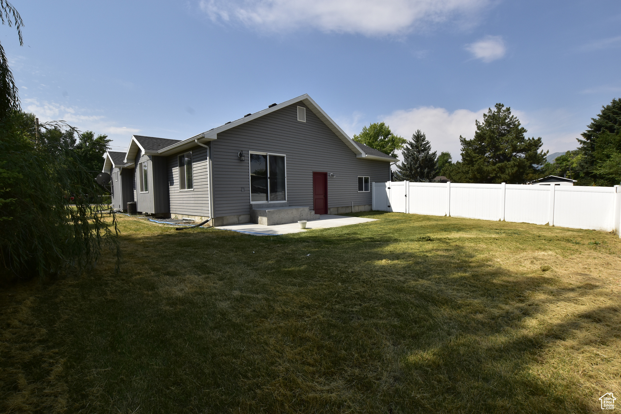 Rear view of house with a patio area and a lawn