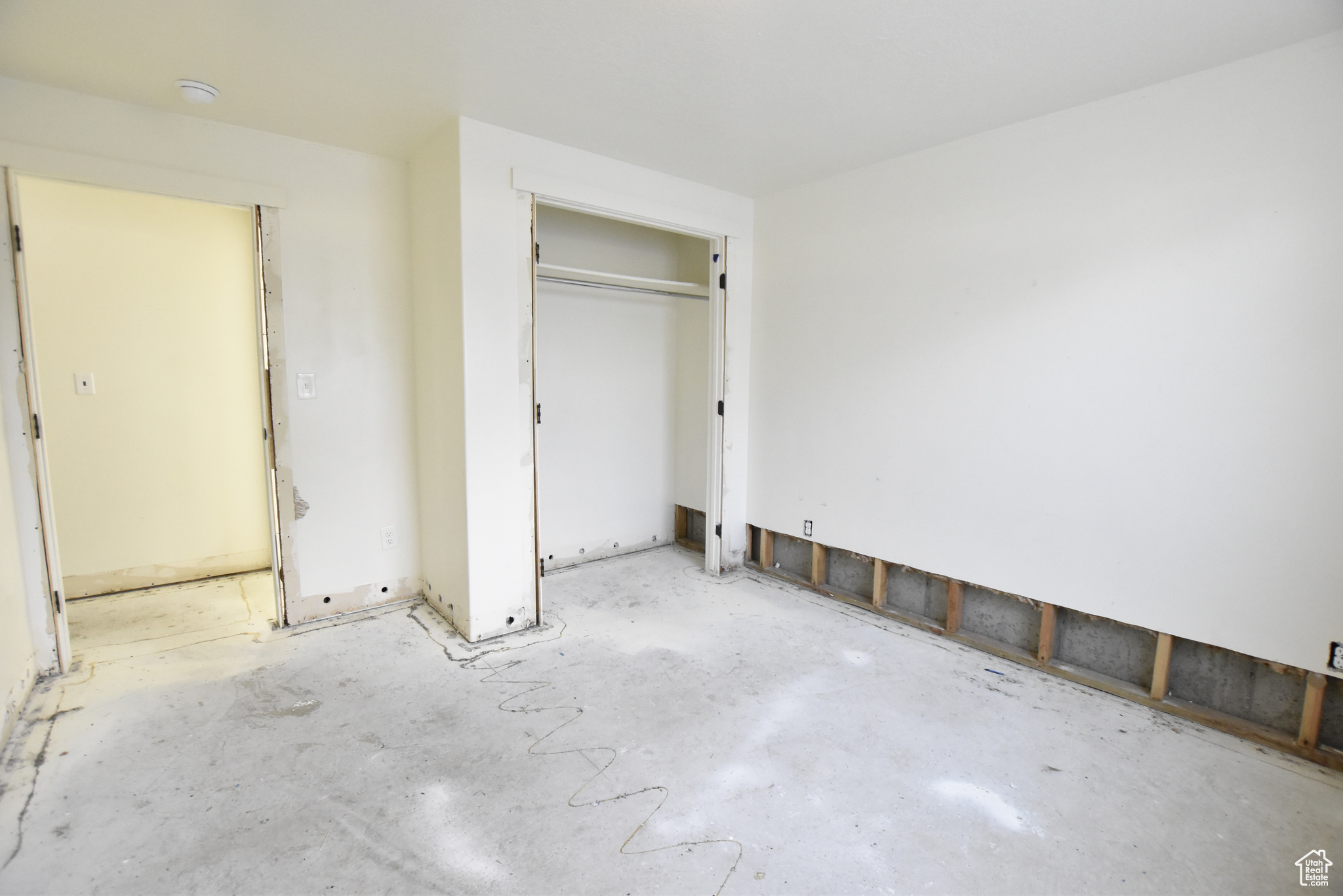 Unfurnished bedroom with concrete flooring and a closet