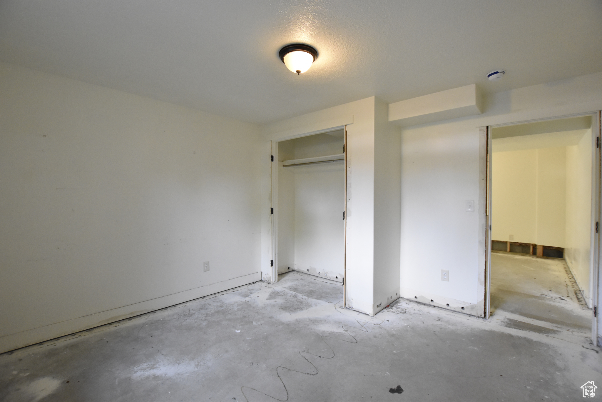 Unfurnished bedroom featuring a closet and concrete floors