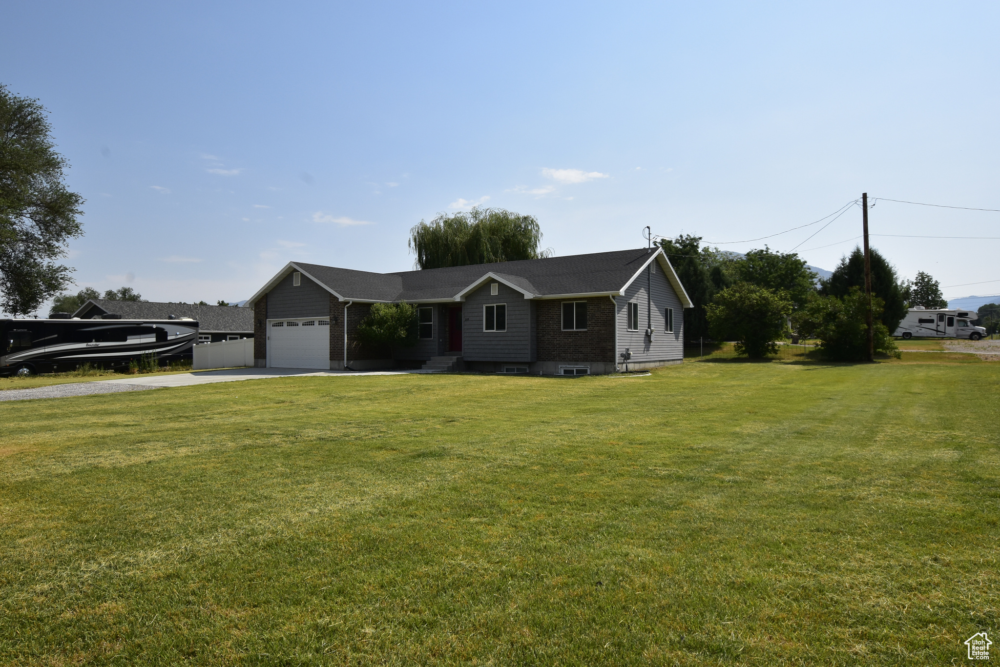 Ranch-style home featuring a garage and a front lawn