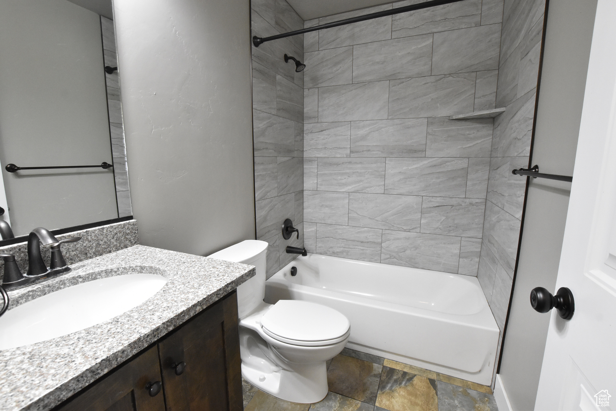 Full bathroom with vanity, toilet, tiled shower / bath, and tile patterned flooring