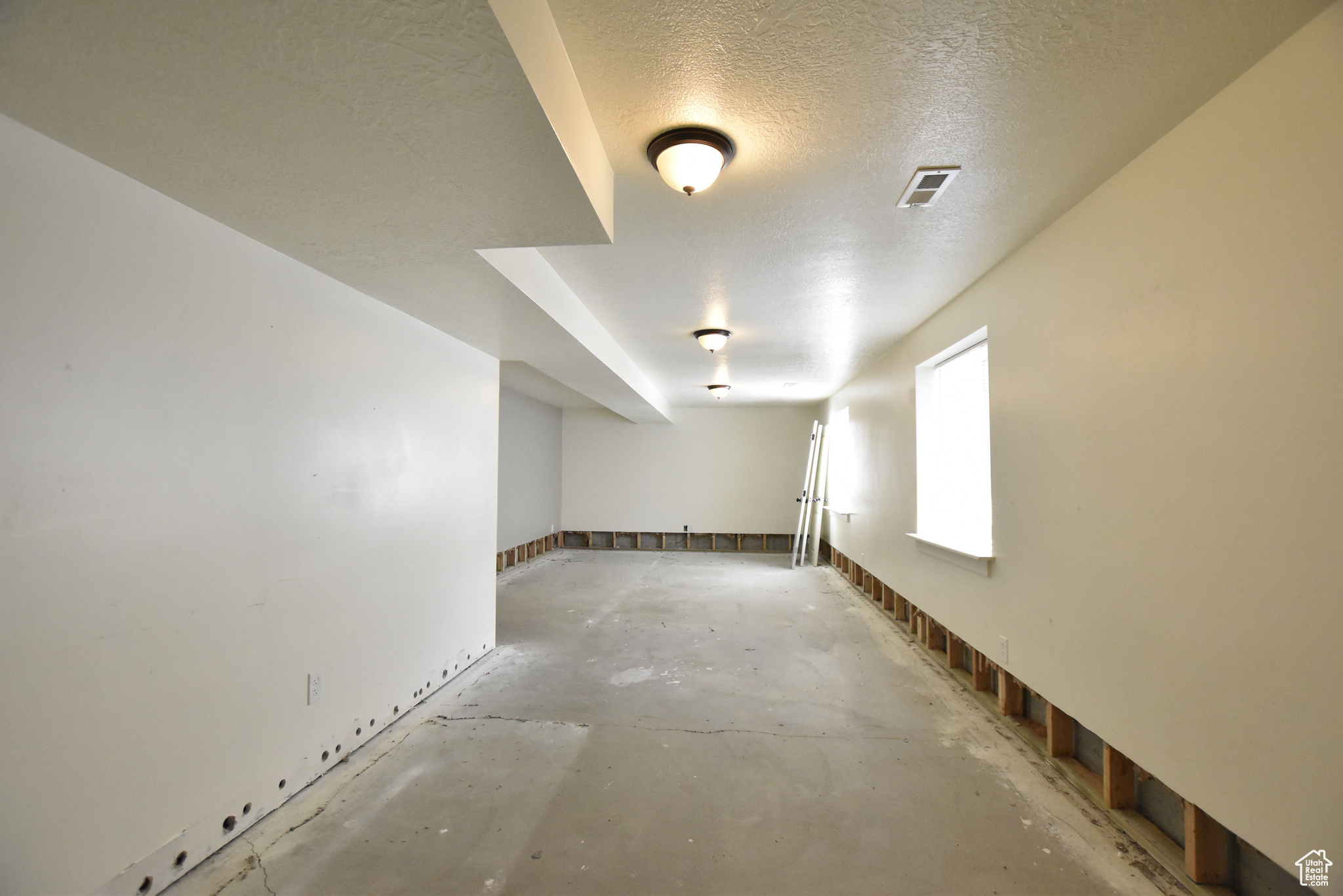 Spare room with concrete flooring and a textured ceiling