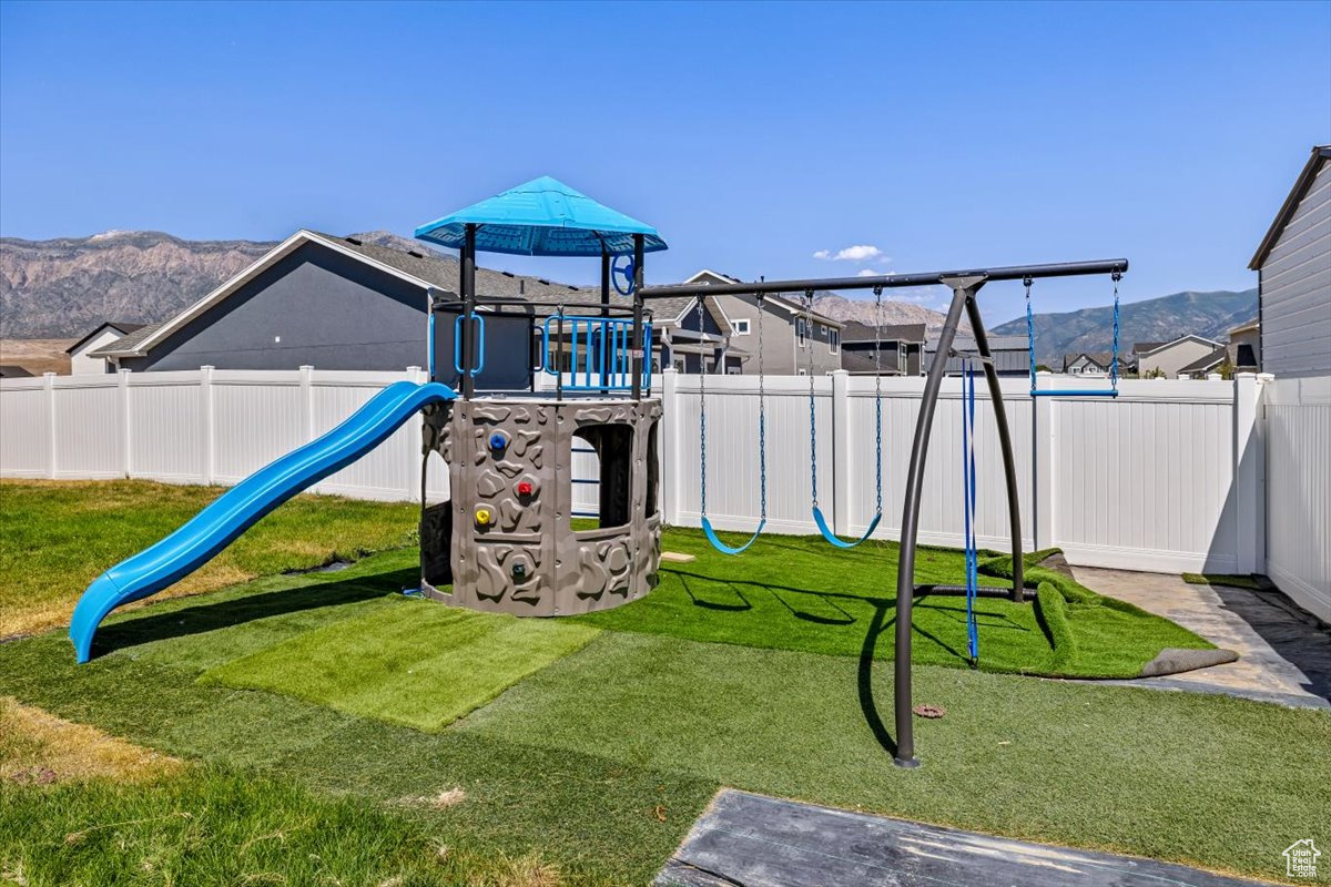 View of play area featuring a mountain view and a yard