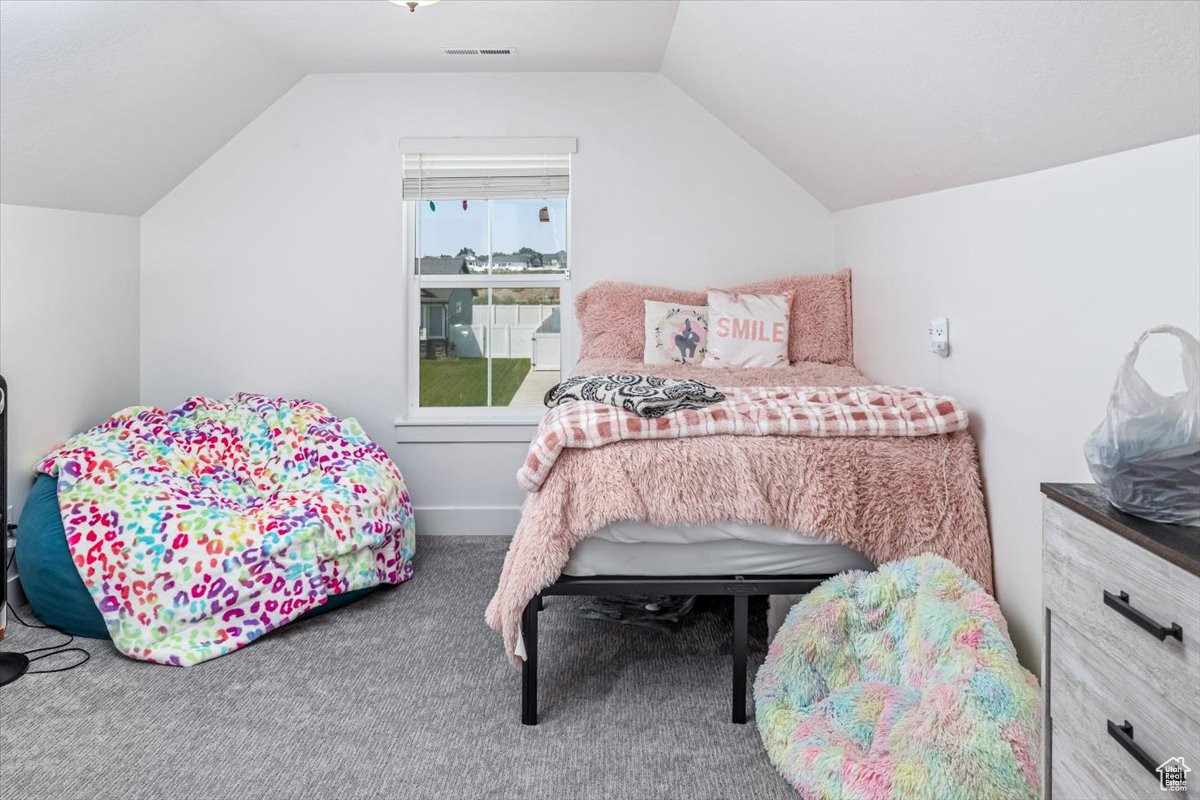 Bedroom with carpet and vaulted ceiling