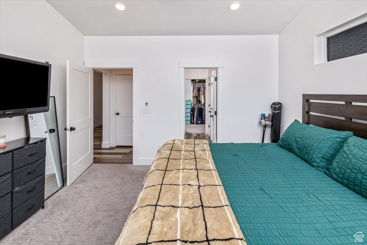 Carpeted bedroom with a closet and a spacious closet