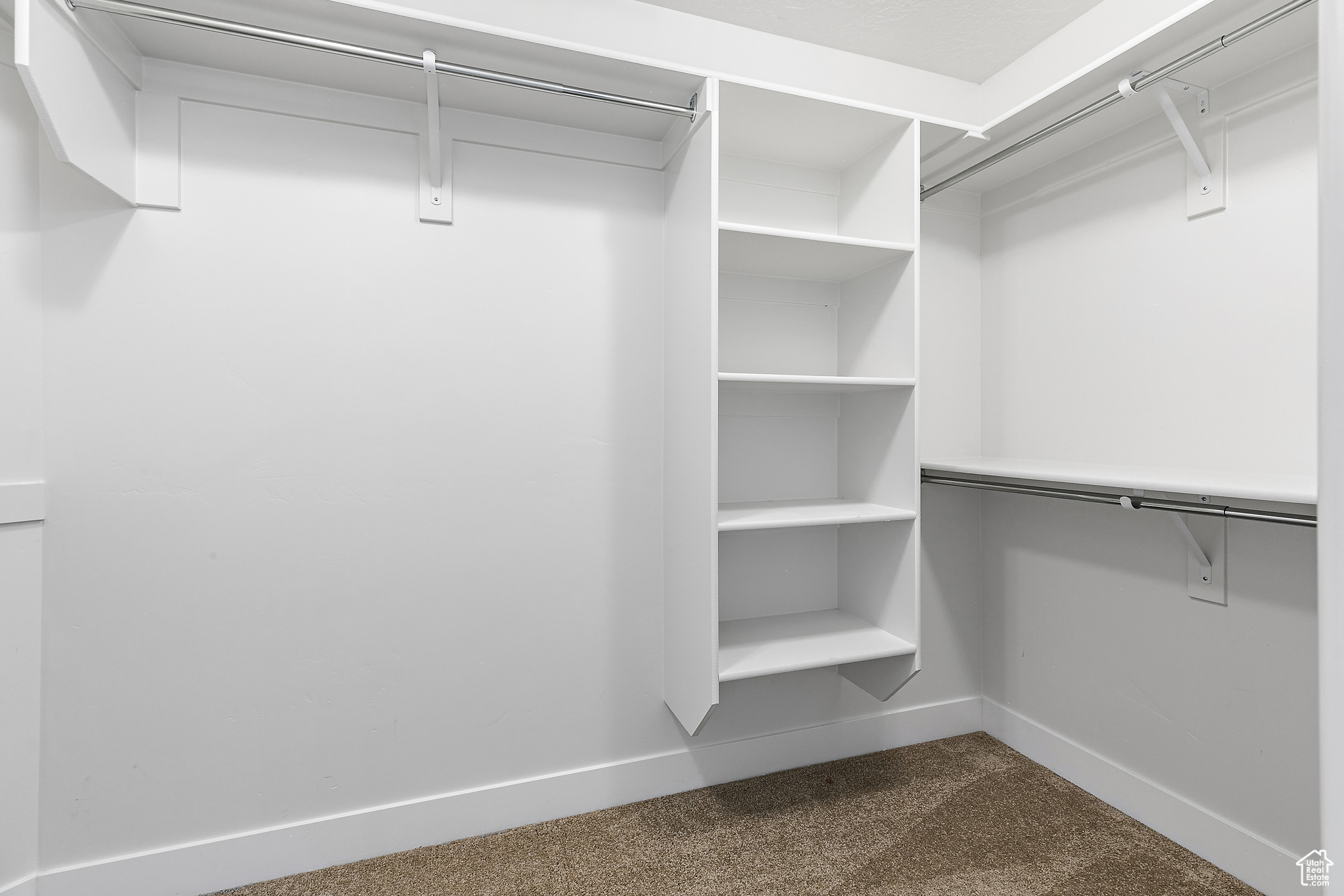 Spacious closet with dark colored carpet