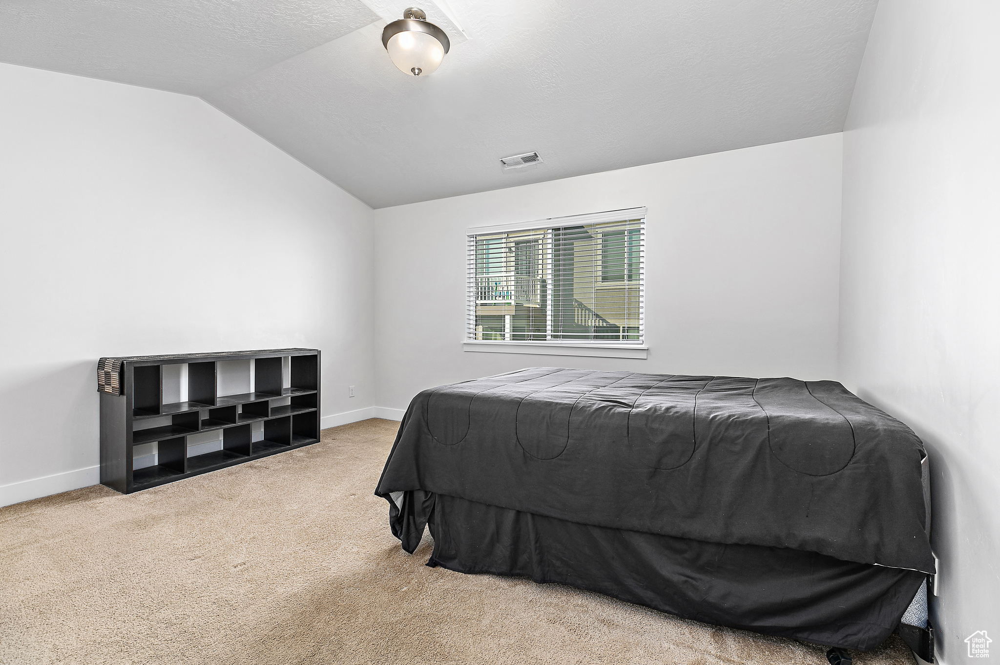 Bedroom featuring carpet flooring and vaulted ceiling