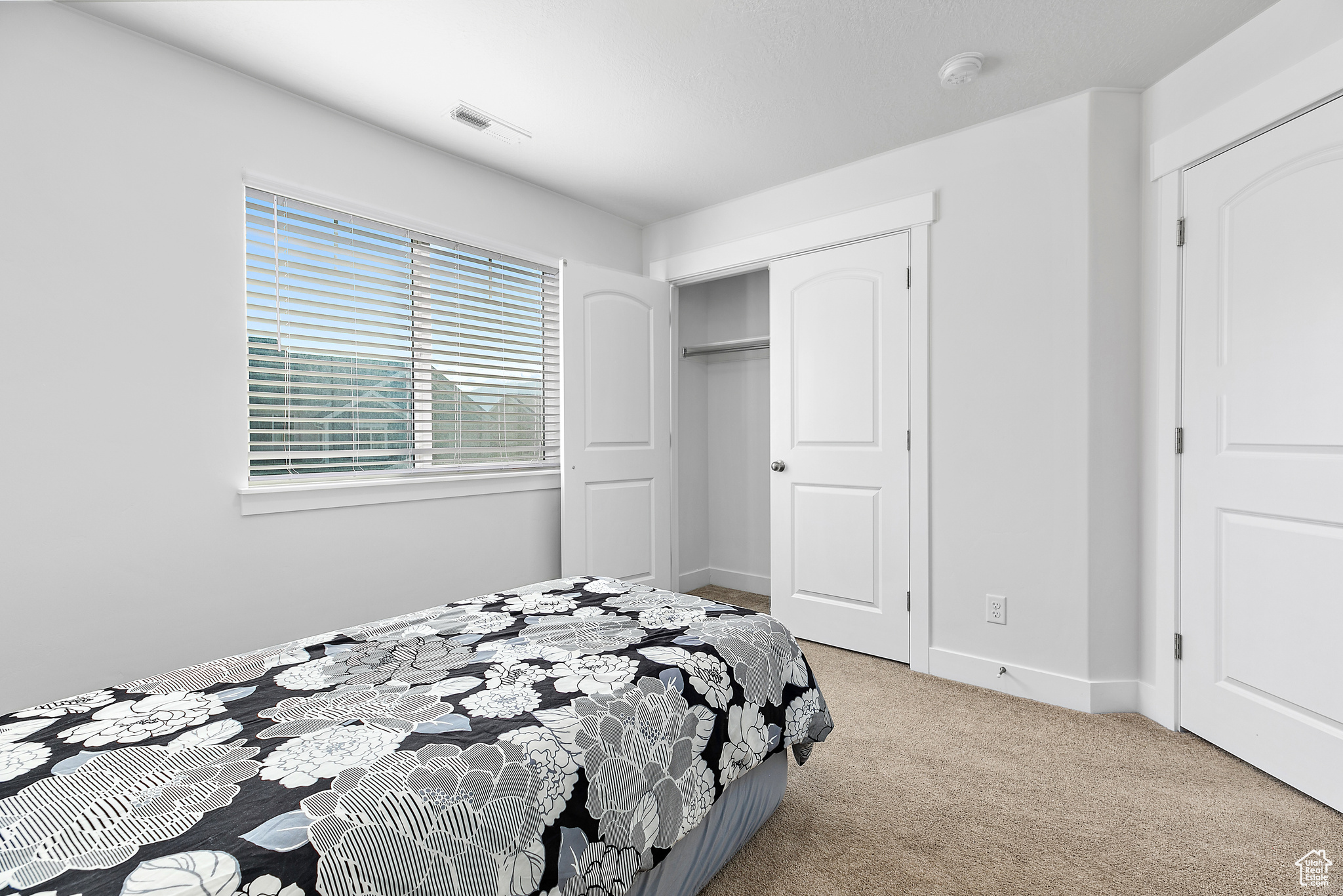 Carpeted bedroom with a closet