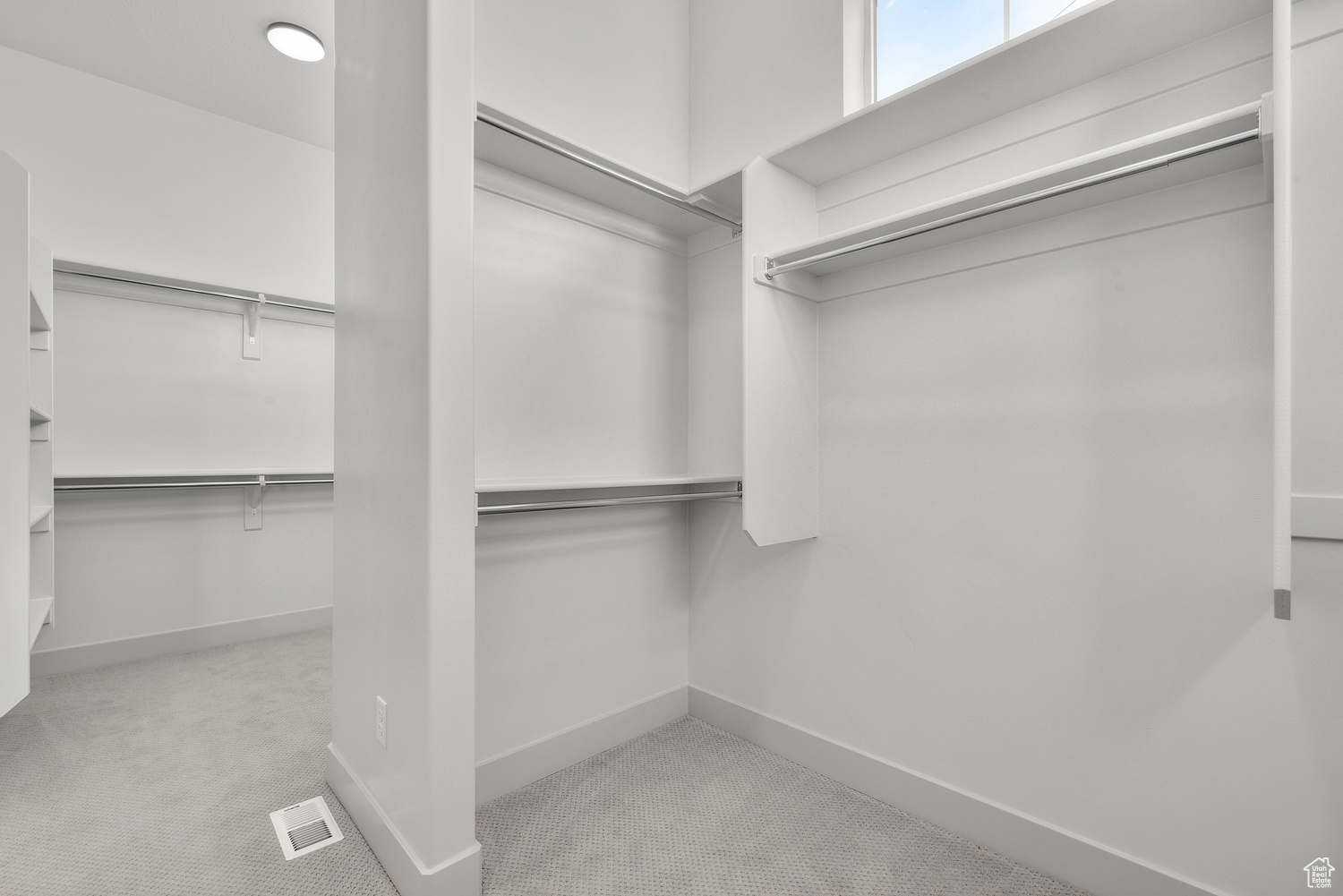 Walk in closet featuring light colored carpet