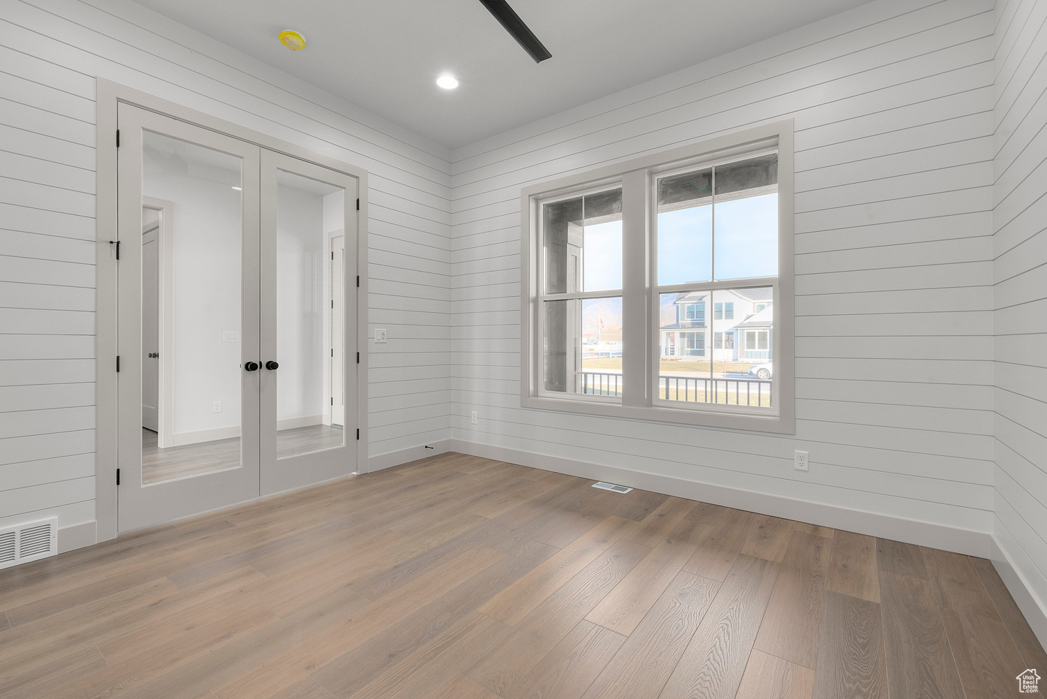 Spare room featuring wood walls and light hardwood / wood-style flooring