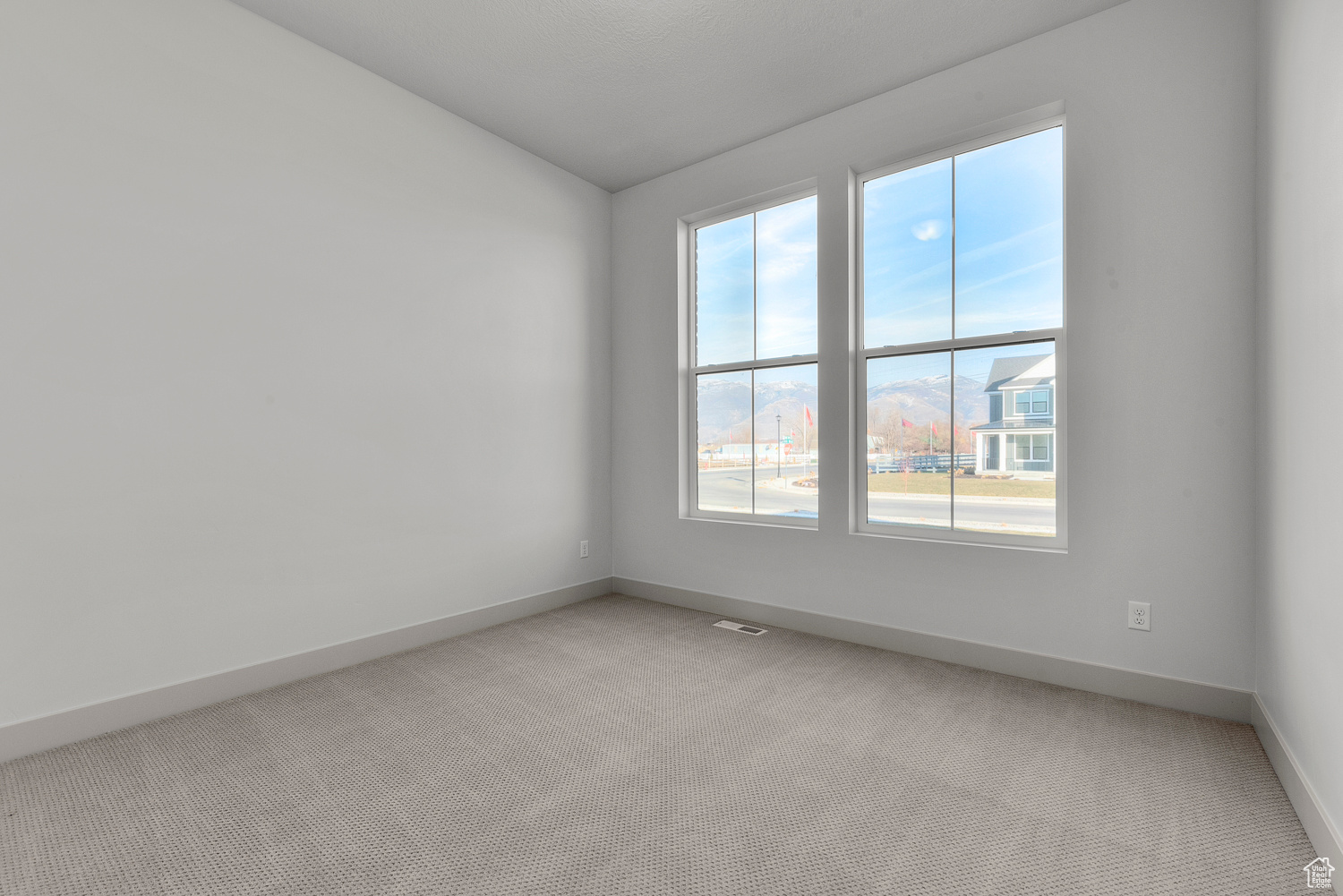 Unfurnished room with lofted ceiling and light carpet