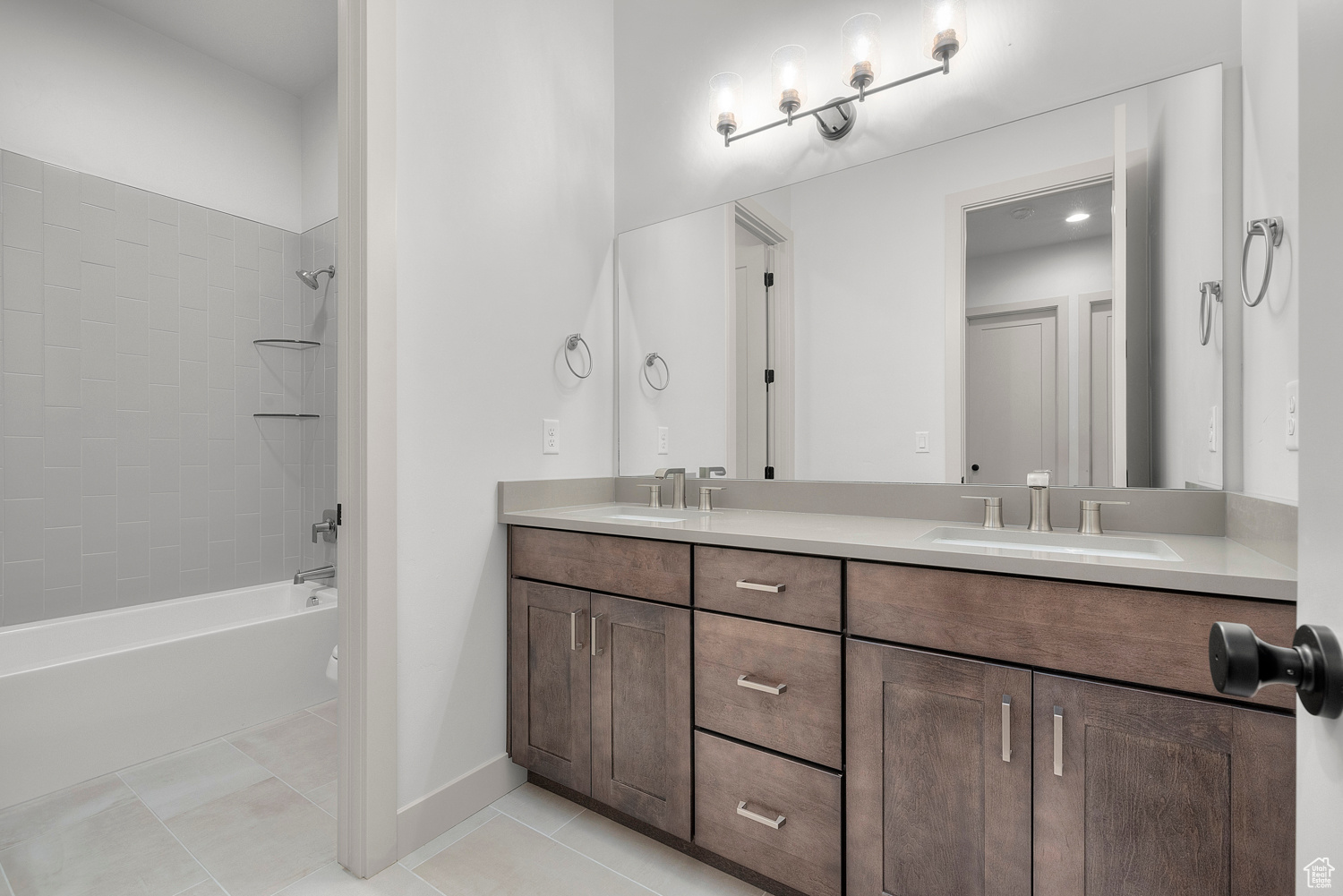 Bathroom featuring tile patterned floors, vanity, and tiled shower / bath