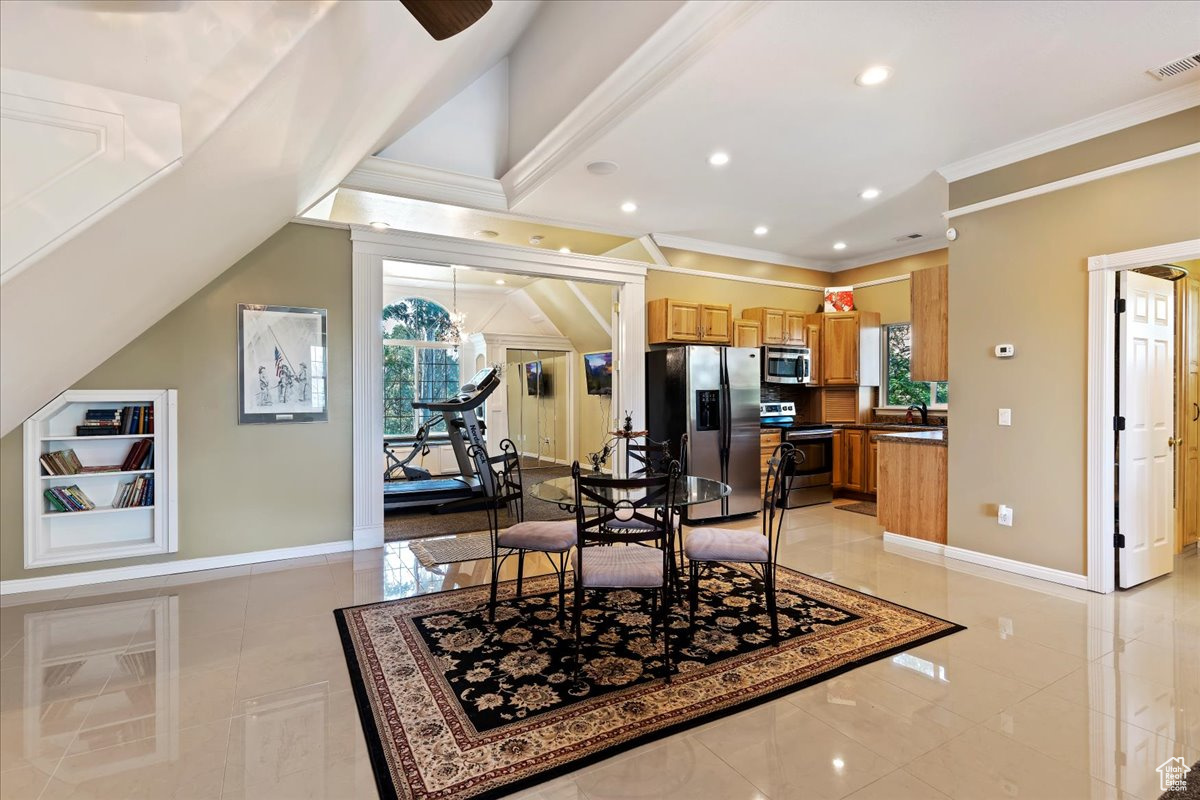 Dining room featuring crown molding, sink, and light tile patterned floors