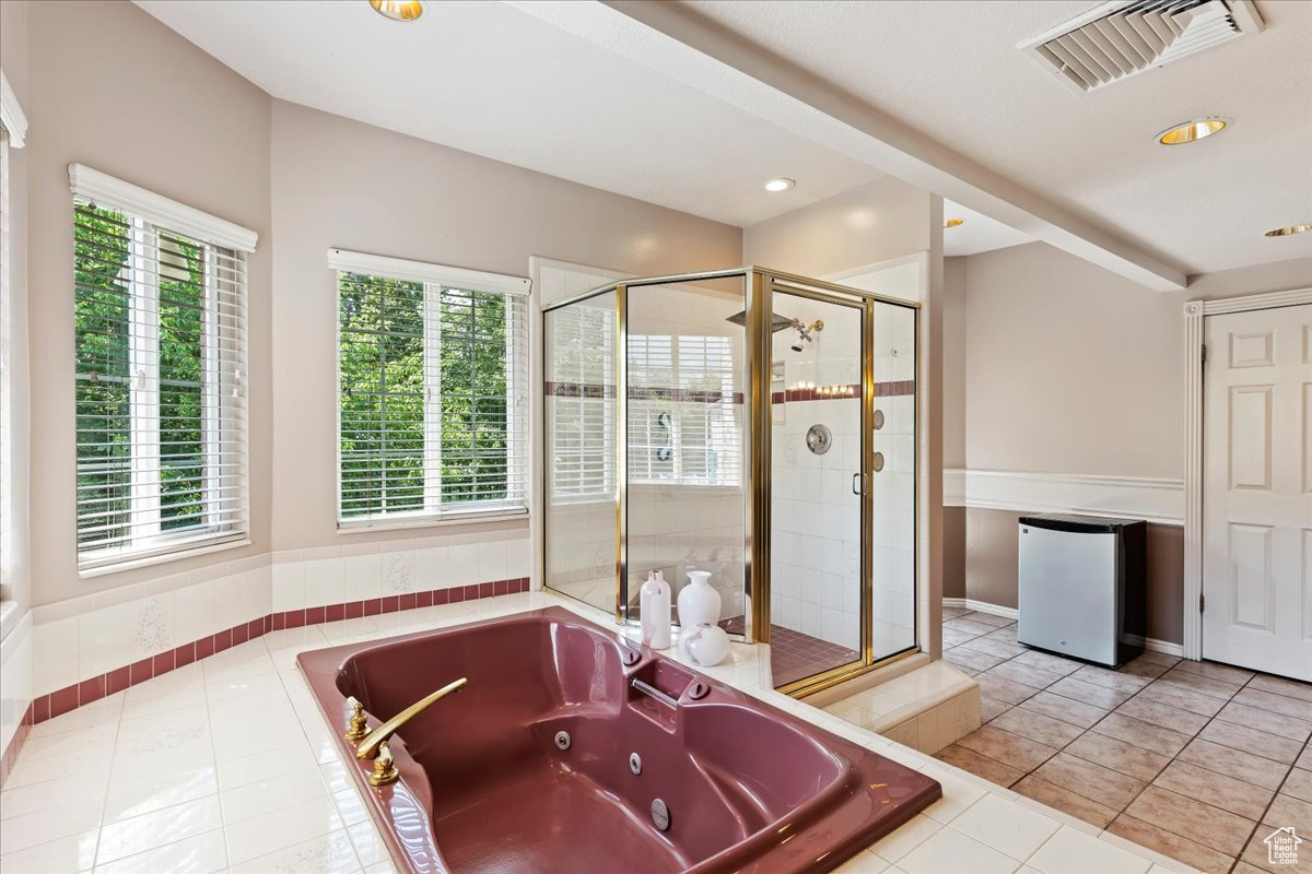 Bathroom with shower with separate bathtub and tile patterned flooring