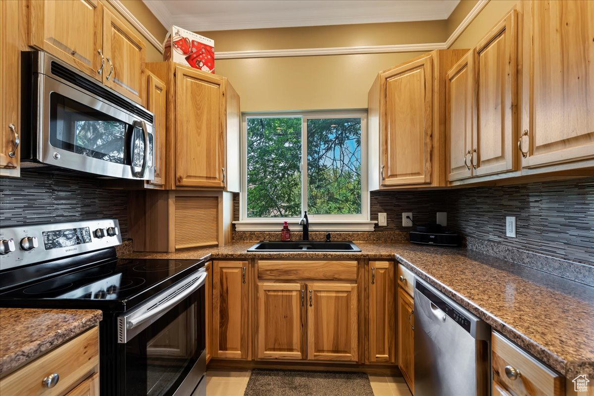 Kitchen featuring sink, appliances with stainless steel finishes, and backsplash